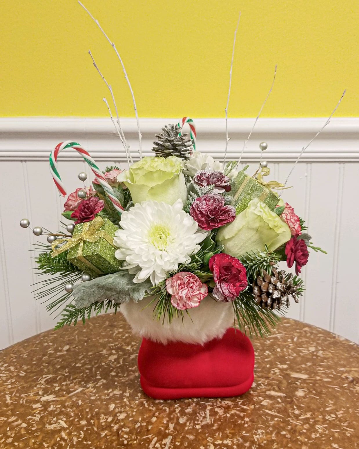Santa's Boot - Someone left his boot behind.  So we filled it with this charming floral arrangement .  Vase is an approx. 6 inch flocked red  and faux fur Santa boot vase and seasonal flowers.