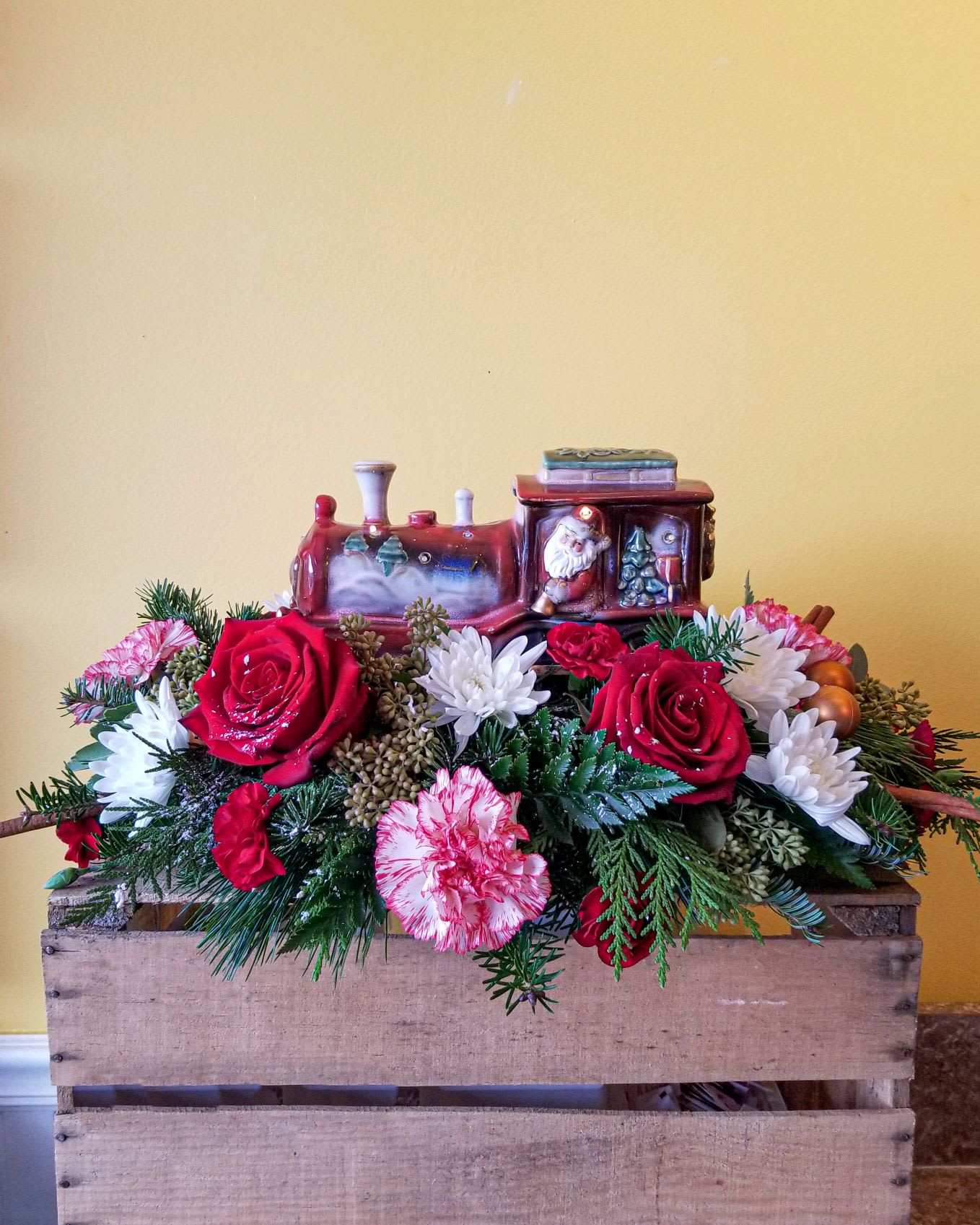 Santa Express - Oh what fun it is to celebrate Christmas at the North Pole with Santa and his elves as they prepare for their Big Night. Take the Santa Express to get on for the ride !.  This centerpiece is highlighted by an antique style Santa train that can be re used as decor long after the arrangement has expired.  lights up too !  
