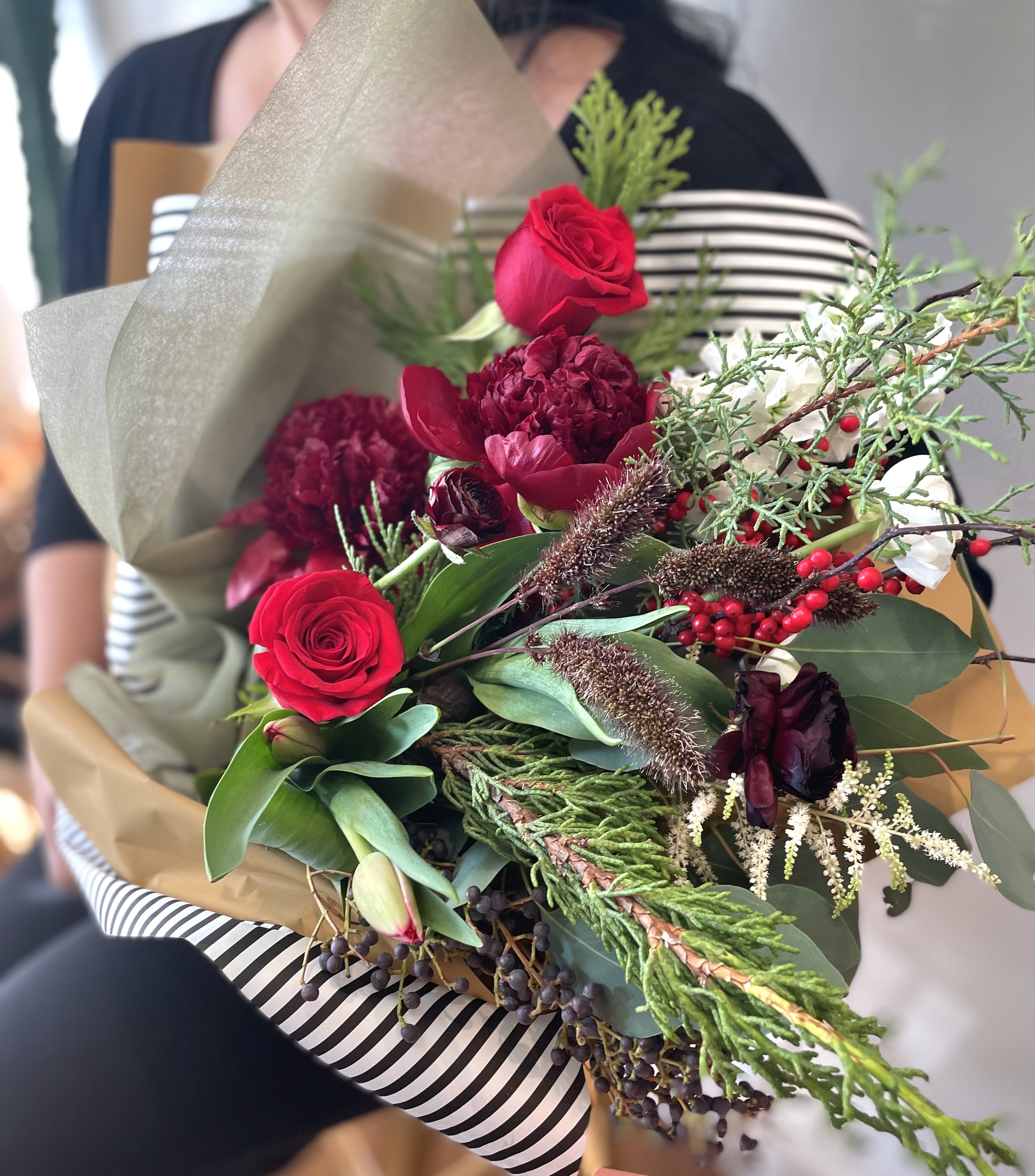 Holiday Bloom Wrap - A beautiful mix of fresh, unique seasonal blooms wrapped in a modern, elegant style. A perfect way to bring a touch of holiday charm to any moment.