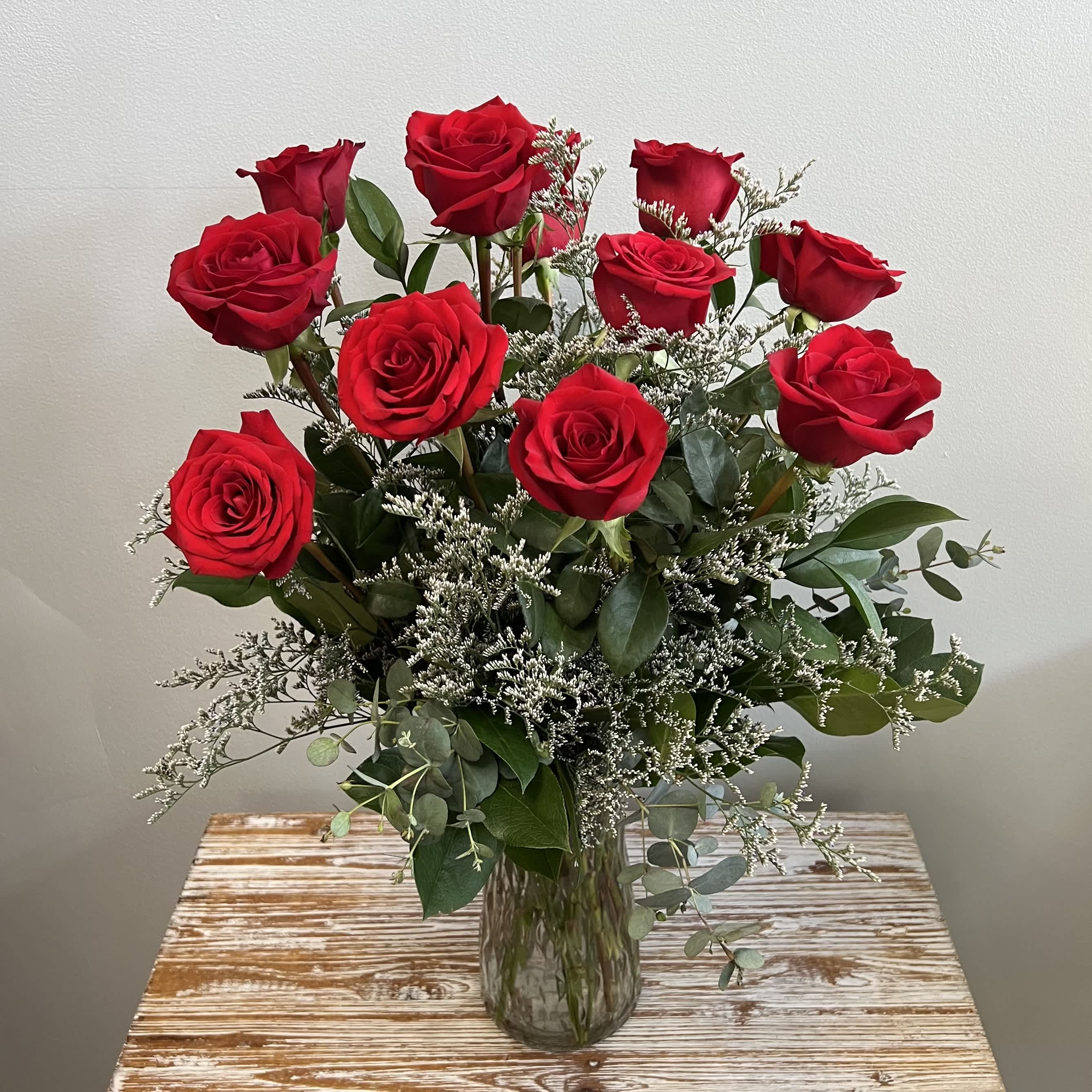 Classic Red Roses - A perfect choice for Valentine’s Day, an Anniversary or Just Because, our Long Stem Dozen Red Roses are the classic statement of love! Standing at over two feet tall, these Long Stem Red Roses contain premium accents and greenery.  Product Description: One Dozen Long Stem Red Roses in Vase accented with wispy Limonium (or similar) and greenery. Arrangement is approximately 24” Tall.