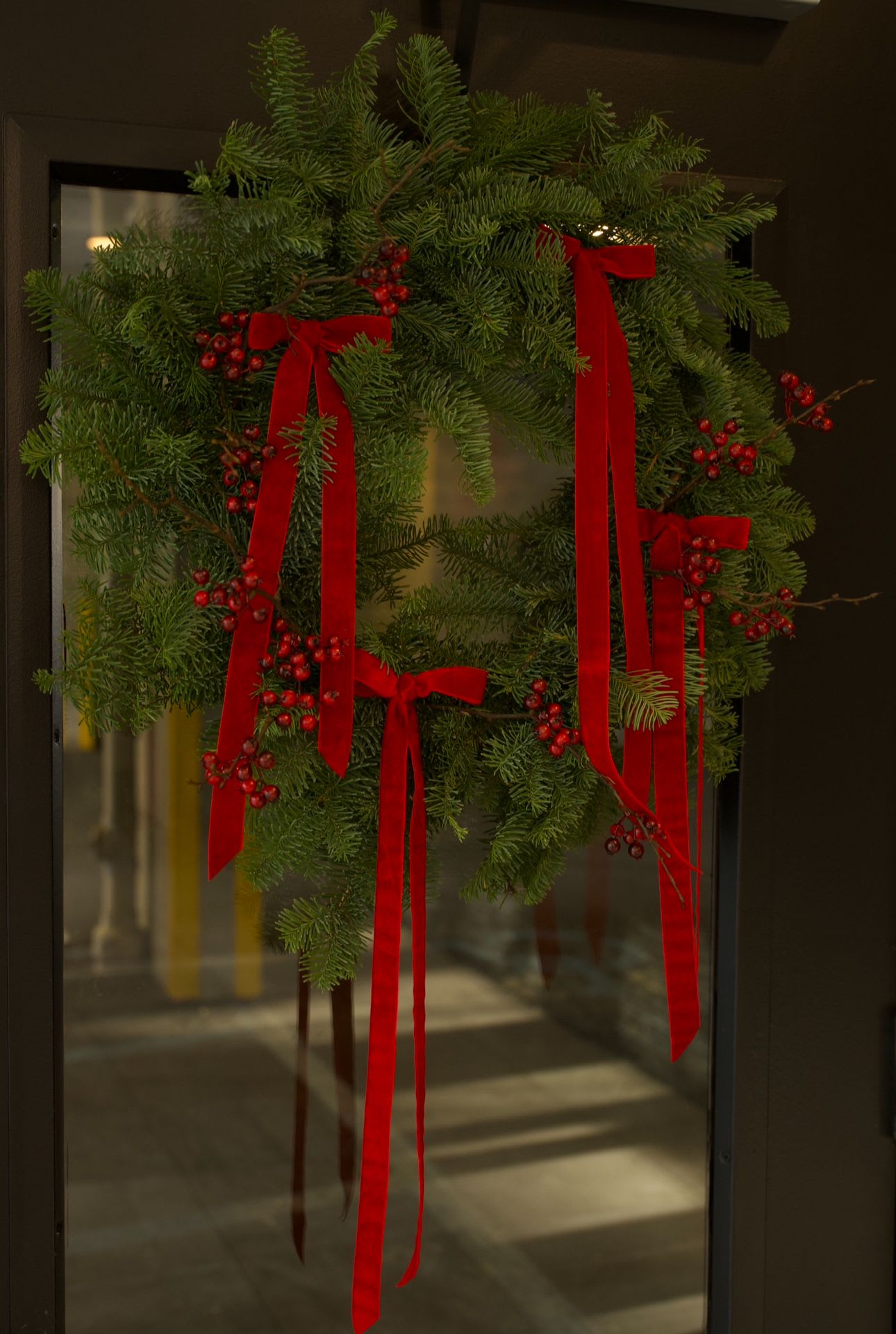Red Velvet Wreath - Where classic holiday tradition meets elegant velvet design.  A classic holiday wreath handcrafted from fresh Christmas fir and styled with long, cascading red velvet ribbons and subtle berry accents. Designed to bring a warm, elegant touch to your home, this wreath is perfect for front doors, apartment entryways, fireplaces, or festive interior walls.  Each wreath is made to order, allowing for slight adjustments in ribbon length and overall fullness. The photo shown displays our 16-inch premium full-size wreath, ideal for standard and large doors. A 14-inch version is also available for compact doors or interior spaces.  ⸻  Substitution &amp; Natural Variation  Because each wreath is handcrafted using fresh fir, slight variations in fullness, ribbon placement, and berry detail may occur. The overall Red Velvet design, color palette, and full holiday look will always remain the same.