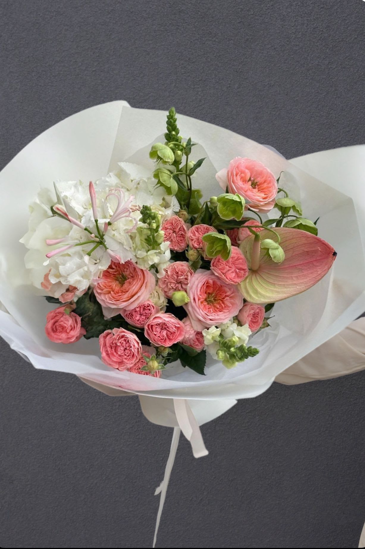 Runway Rose' - A high-fashion floral arrangement with ruffled garden roses, crisp anthurium, and layers of soft texture. Think of it as a runway gown reimagined in petals — graceful, intentional, and beautifully bold.