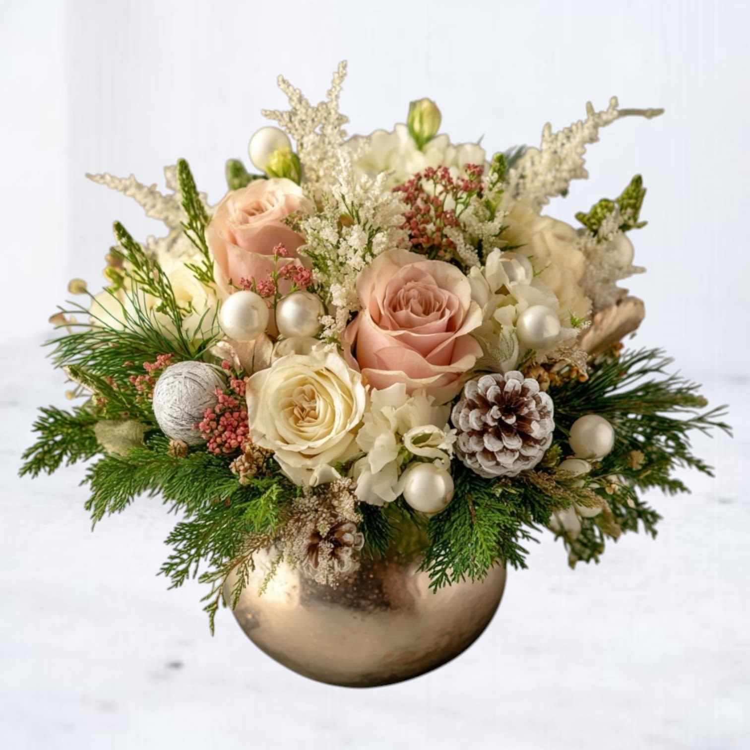 Champagne Blush - Soft, elegant, and winter-kissed, the Champagne Blush Arrangement features blush roses, creamy white blooms, and snow-dusted pinecones nestled among fresh seasonal evergreens. Pearl accents and delicate winter textures add a touch of holiday sophistication, all arranged in a shimmering champagne-gold bowl.  Handcrafted by Whiskey Wallflower, this design blends luxury and softness for a timeless winter statement piece. Perfect for holiday tables, gifting, or adding a refined touch to your seasonal décor, it brings warmth and understated glamour to any space.  Available for same-day Christmas and winter flower delivery in Magnolia, The Woodlands, Conroe, Tomball, and surrounding Houston areas.