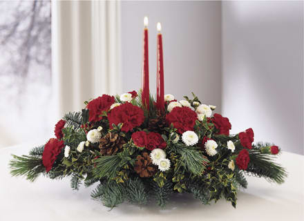Treasured Traditions Holiday Centerpiece - Holiday flowers. Share the joy this seaon with a festive fresh arrangement with red and white flowers, winter greens and pinecones. Two red taper candles add seasonal charm to this centerpiece. 