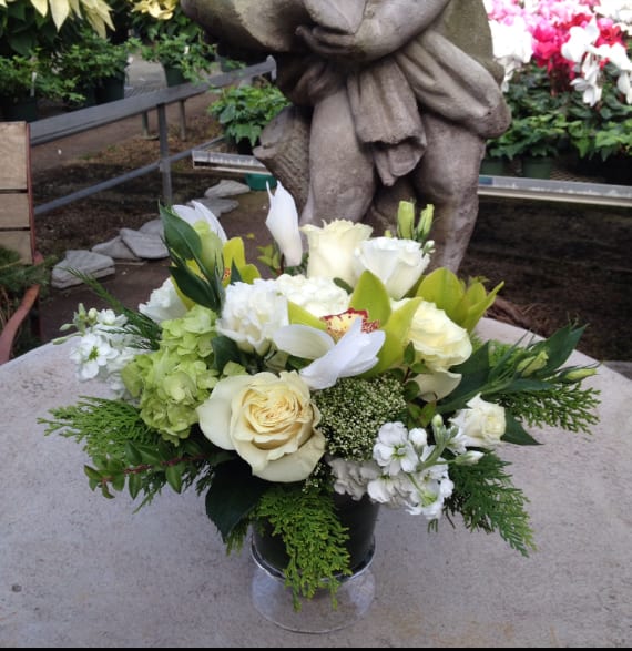 Classic White - Cymbidiums and roses make up this beautiful arrangement comprised in an urn.