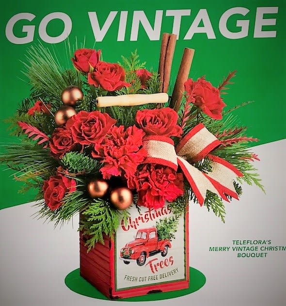 Go Vintage - A charming vintage-inspired metal cube filled with red spray roses, red carnations, fragrant evergreens accented with balls, ribbon and cinnamon sticks