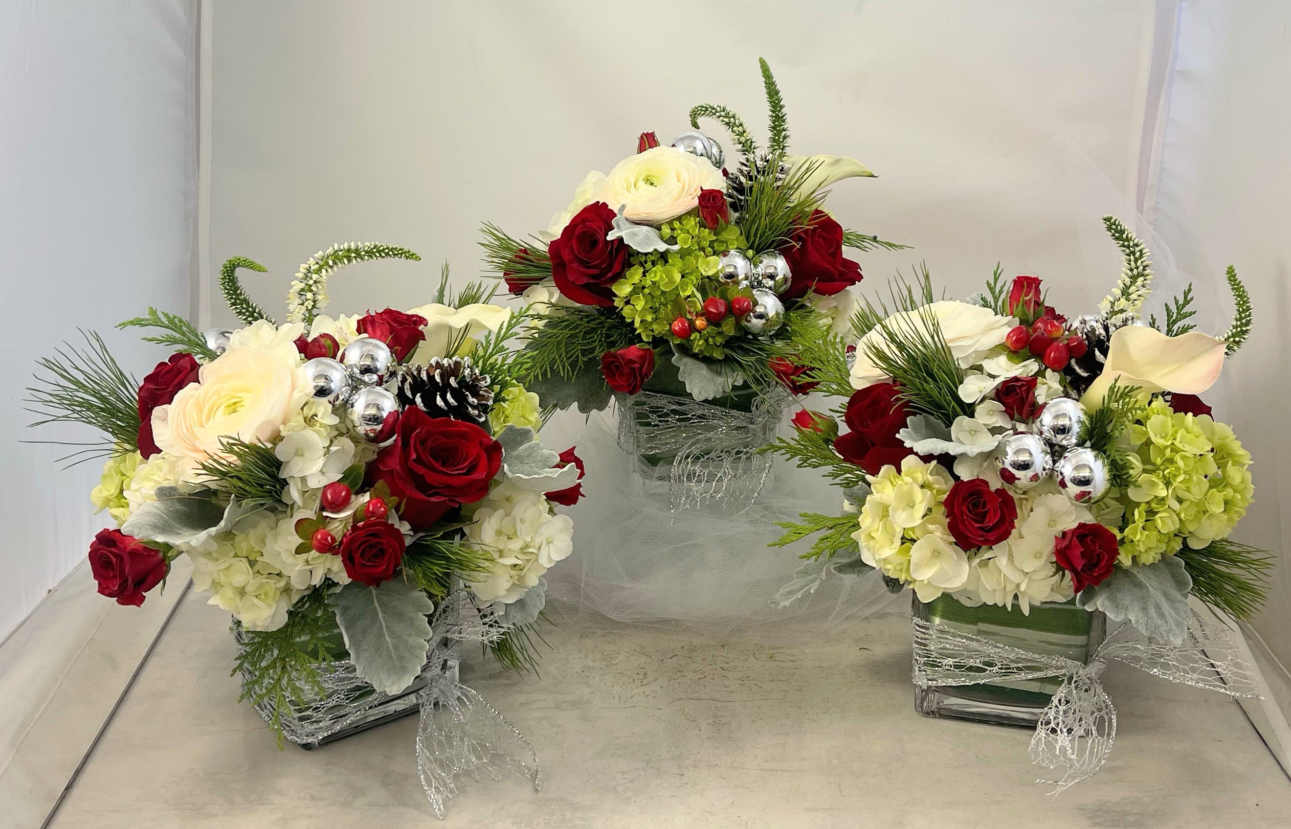 Christmas Trio Silver - Why have one centerpiece when you can have three!!!  Space three smallerChristmassy designs artfully down the center of the table, leaving ample room for the main attraction. Having three centerpieces also gives you the opportunity to share the floralholiday joy with your guests!