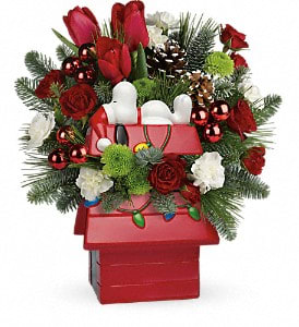 Snoopy's Merry Doghouse Jar  - This fun-filled holiday gift features everyone's favorite pooch catching a few Christmas ZZZs atop his delightful doghouse. Filled with gorgeous red roses and tulips, this hand-painted collectible jar will be the perfect hiding place for mouthwatering Christmas cookies!   This cheerful mix features red spray roses, red tulips, white miniature carnations, green button spray chrysanthemums, noble fir, white pine and seasonal accents. Delivered in Snoopy's Cookie Jar.   Approximately 11 1/2&quot; W x 12 3/4&quot; H  Orientation: All-Around