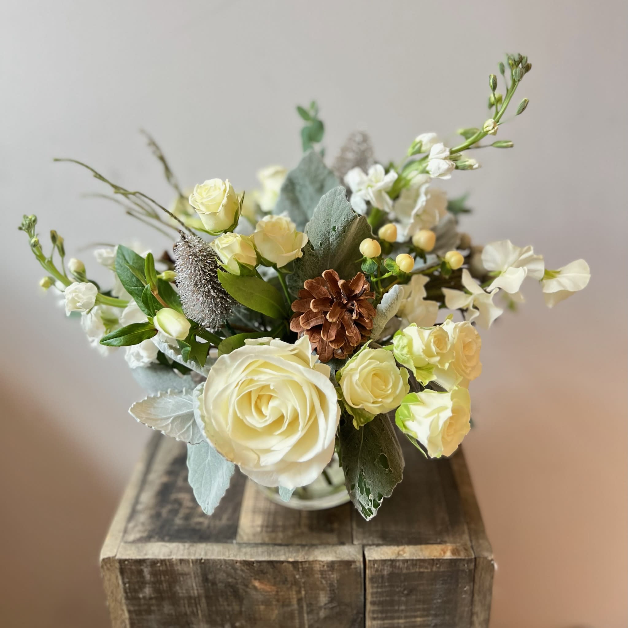 A Winter Morning - Lift the curtain and take a peak outside your window -- you might be treated to the breathtaking morning view of freshly fallen snow that inspires this sweet and sparkling arrangement!  Fresh and chilly excitement awaits in this arrangement of roses, hypericum berries, and other wintry accents.
