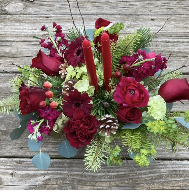 Cozy Holiday - A centerpiece with candles, and seasonal blooms, accented with cones and berries.