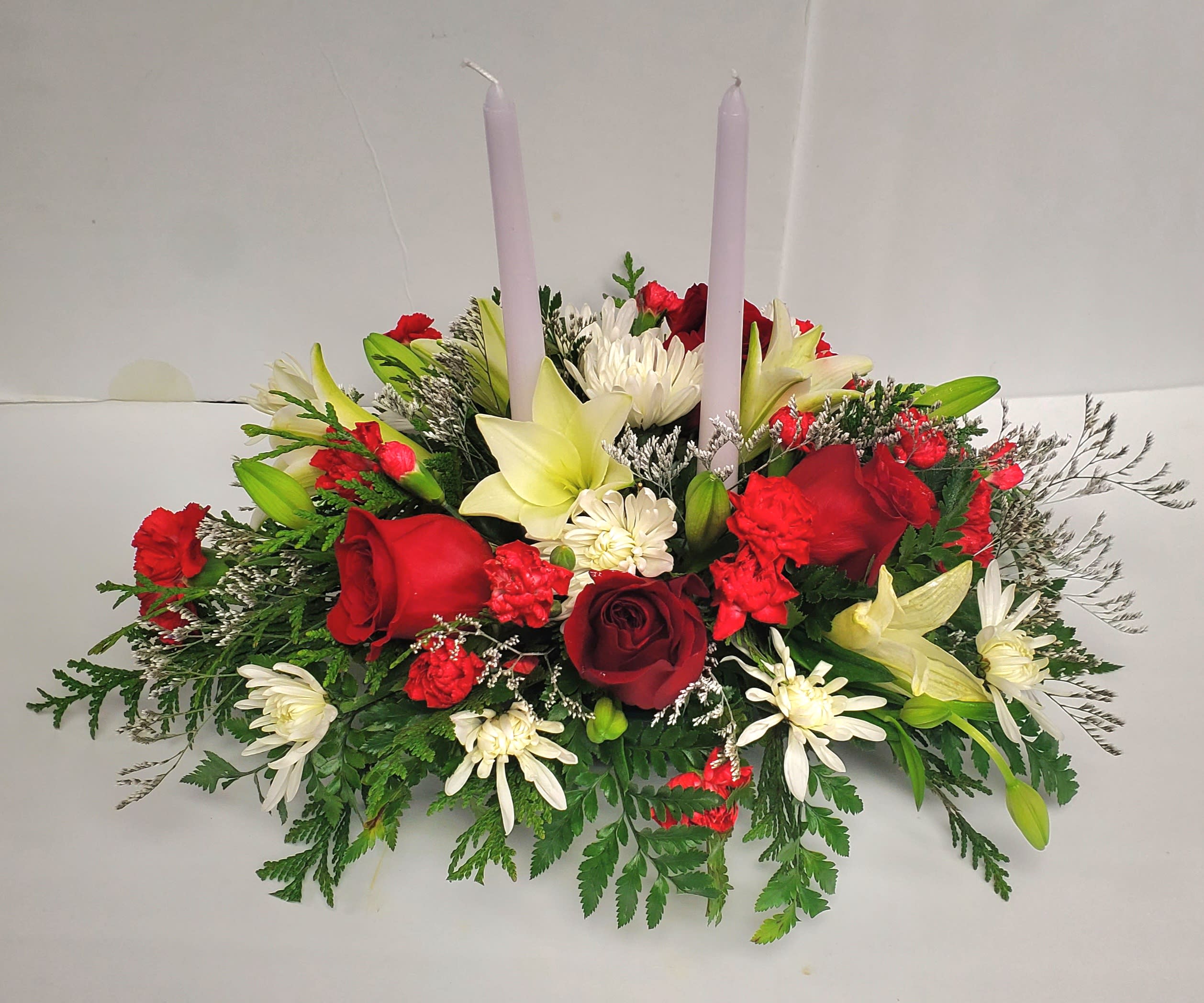 Christmas Joy - Red and white low centerpiece with candles .