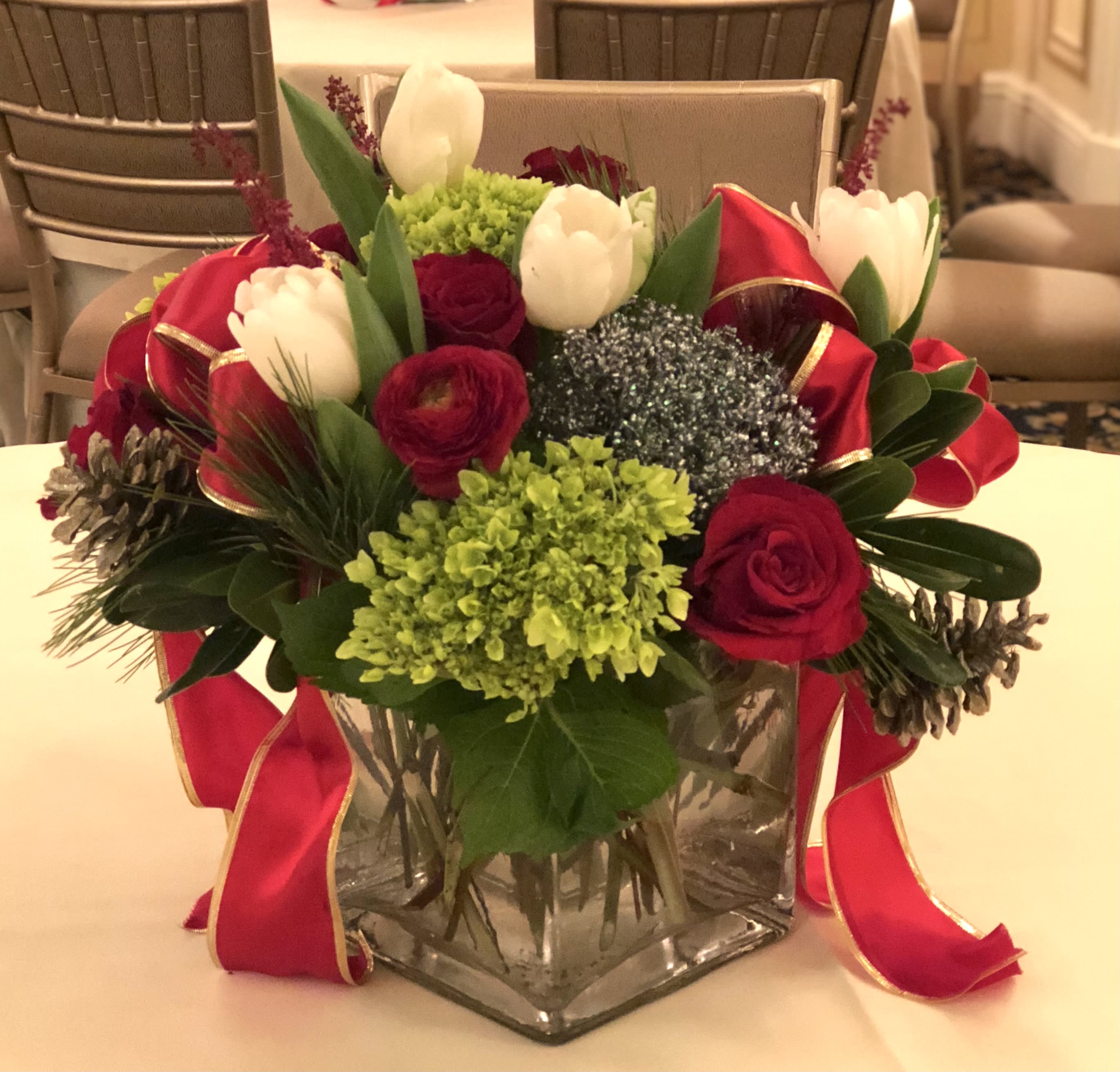 Merry and Bright - Modern glass square vase styled with tulips, roses, evergreens and accents of holiday ribbon, ornaments and pinecones.  