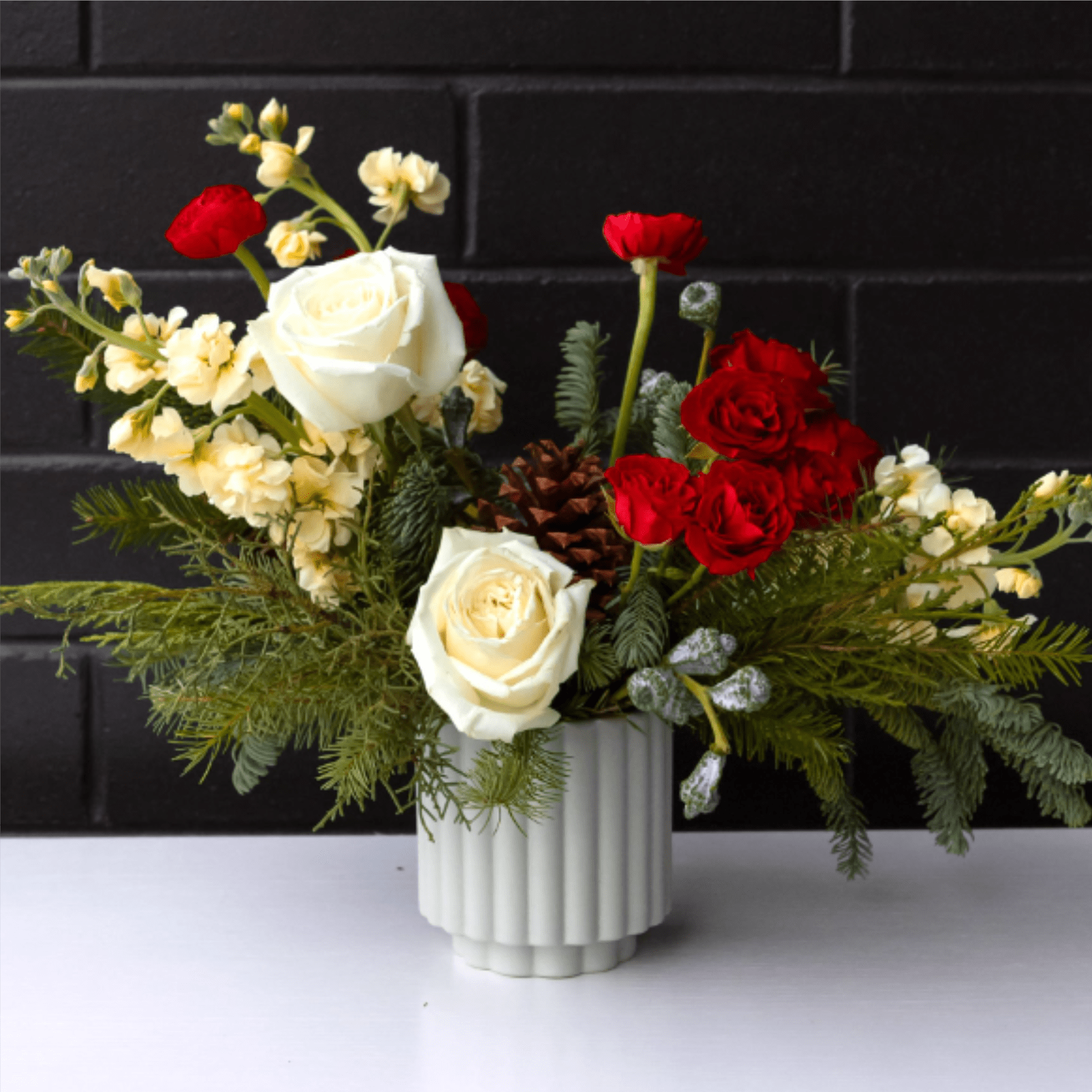 Holiday Designer's Pick - A fun and festive arrangement full of fresh winter greens and red and white blooms! (Photo shown is standard size)