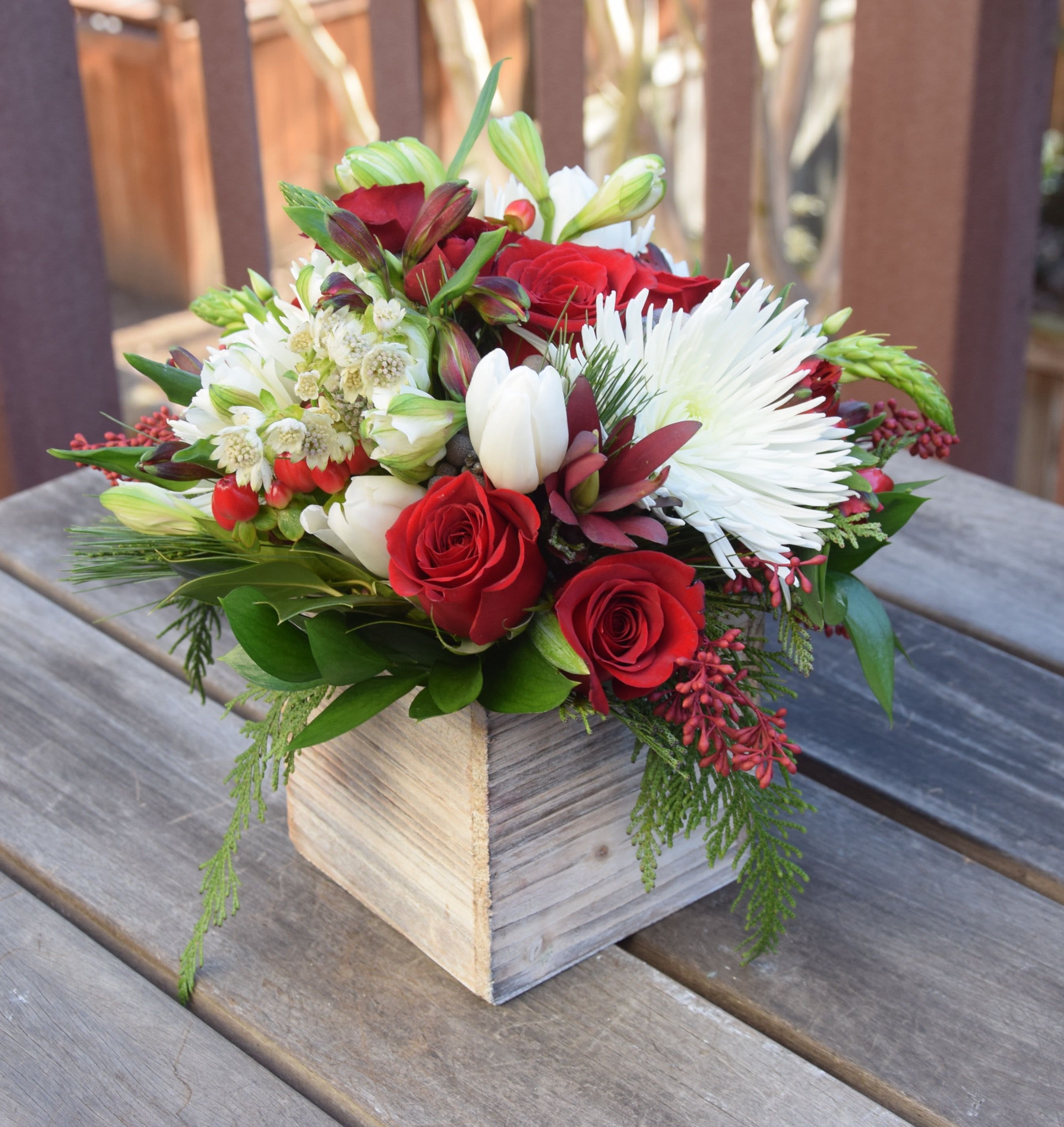Holiday Box of Blooms - A delightful design of seasonal blooms in a hand crafted wooden box. This design is perfect for any occasion. We fill it with the freshest evergreens locally harvested and seasonal color blooms. 