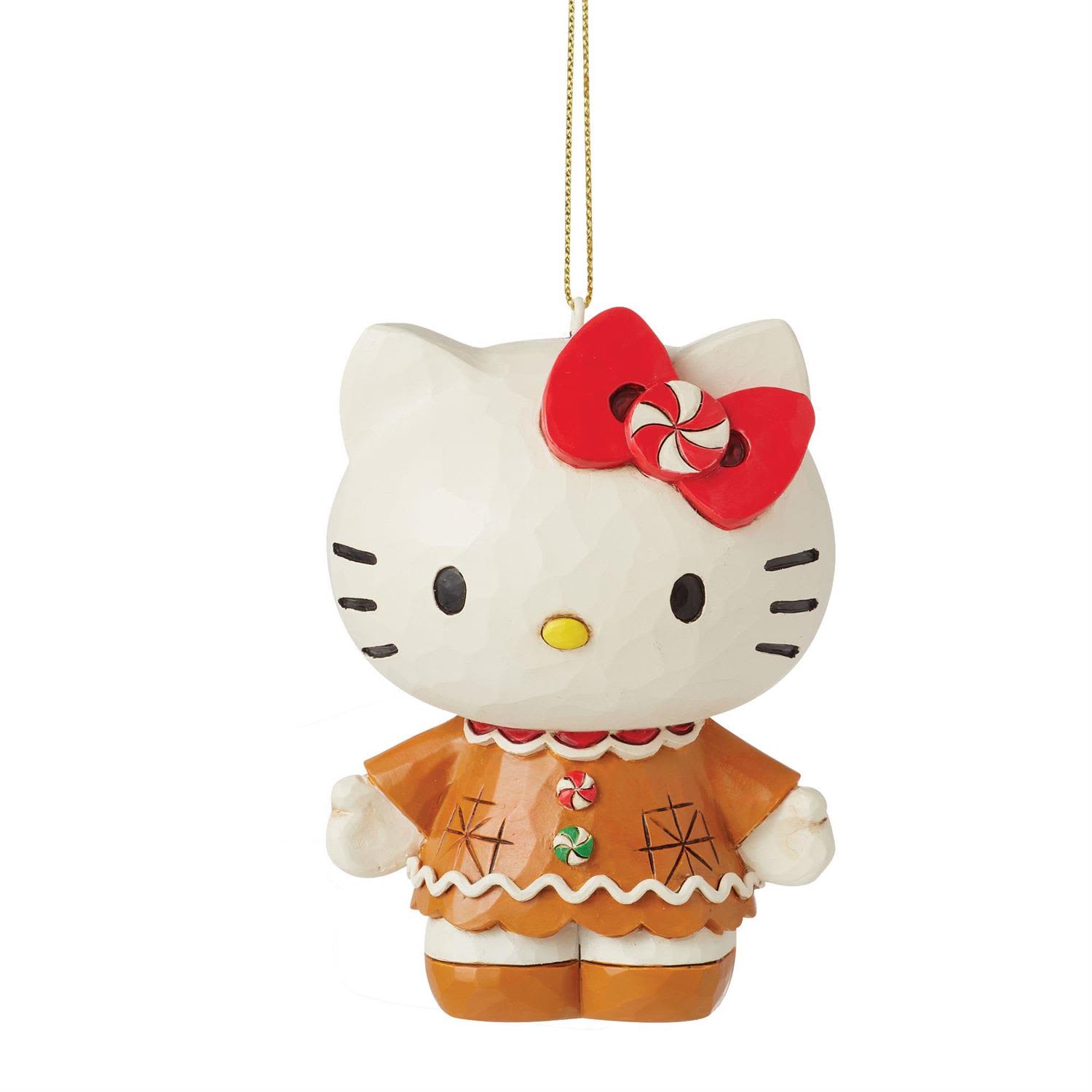 Hello Kitty Gingerbread Ornament - Celebrate the sweetness of the season with this adorable Hello Kitty Gingerbread Ornament from the Jim Shore Sanrio Collection. Hello Kitty is reimagined as a festive gingerbread cookie, complete with peppermint buttons and a matching peppermint bow that adds a charming pop of holiday color. She stands atop a delightful stage of gumdrops and icing, bringing the whimsy of a candy shop and the nostalgia of classic Sanrio together in one irresistible ornament.  Standing 3.5 inches tall, this hanging piece is beautifully hand-painted and crafted from high-quality stone resin, showcasing the intricate patterns, folk-art textures, and signature detailing that make Jim Shore’s work so cherished. Every peppermint swirl, frosted edge, and sweet expression captures the joyful spirit of the holidays.  Each ornament is sold individually and available in limited quantities, making it the perfect collectible for Hello Kitty fans and a delightful addition to any festive décor.