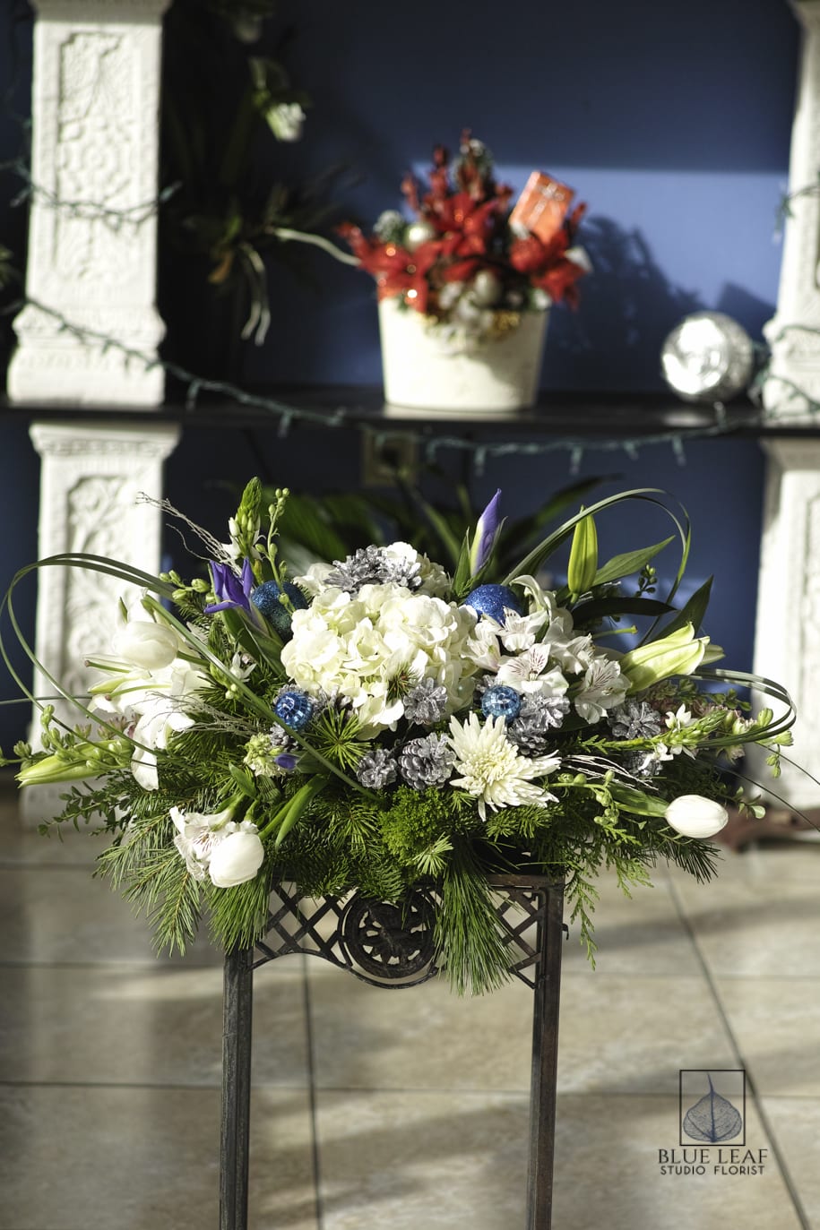 Winterland Centerpiece - Centerpiece in white and blue: included are- hydrangeas, lilies, iris and tulips with sparkley balls and pinecones.