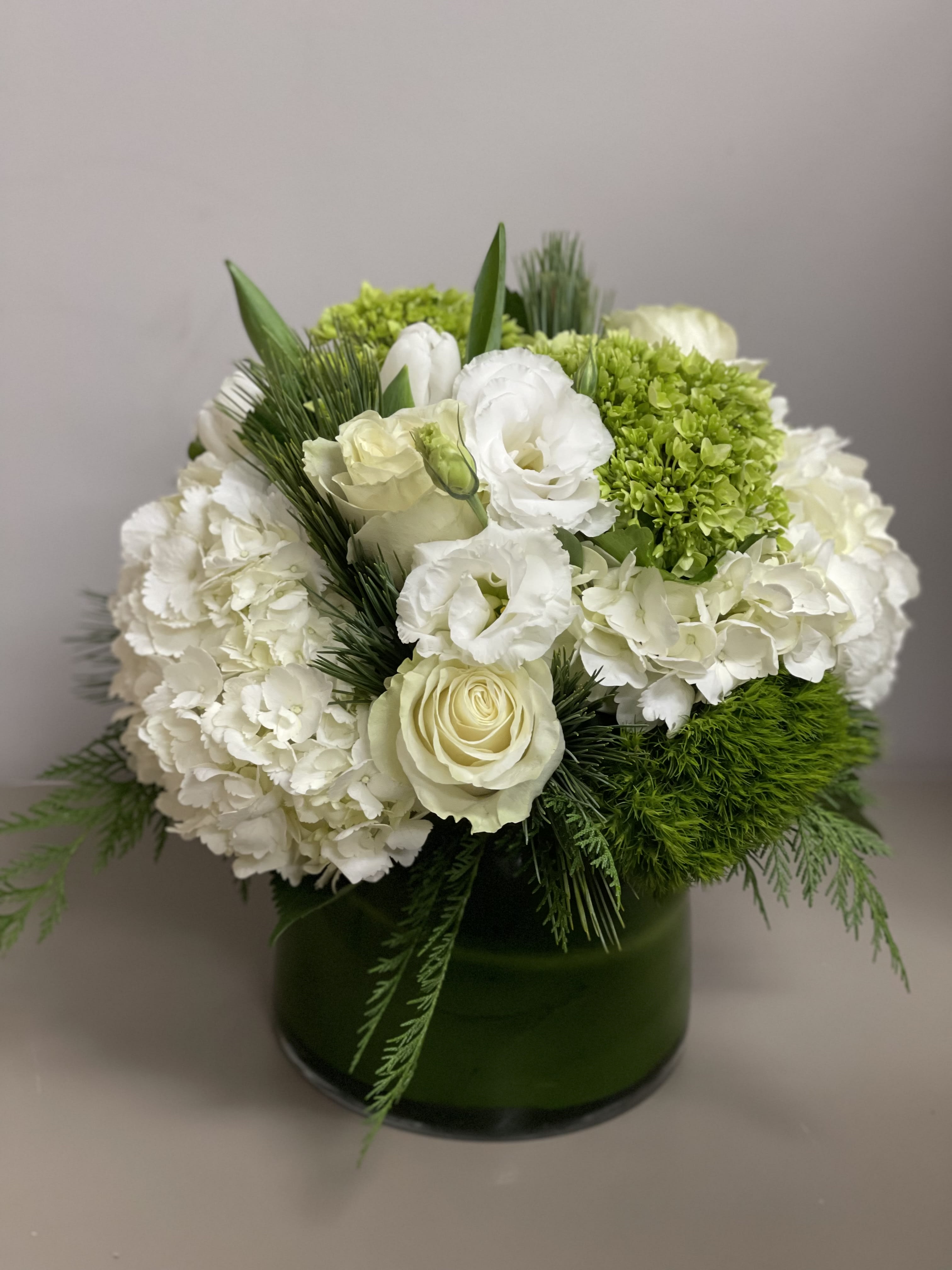 Winter - Beautiful white and green arrangement with Winter greens in a glass container 