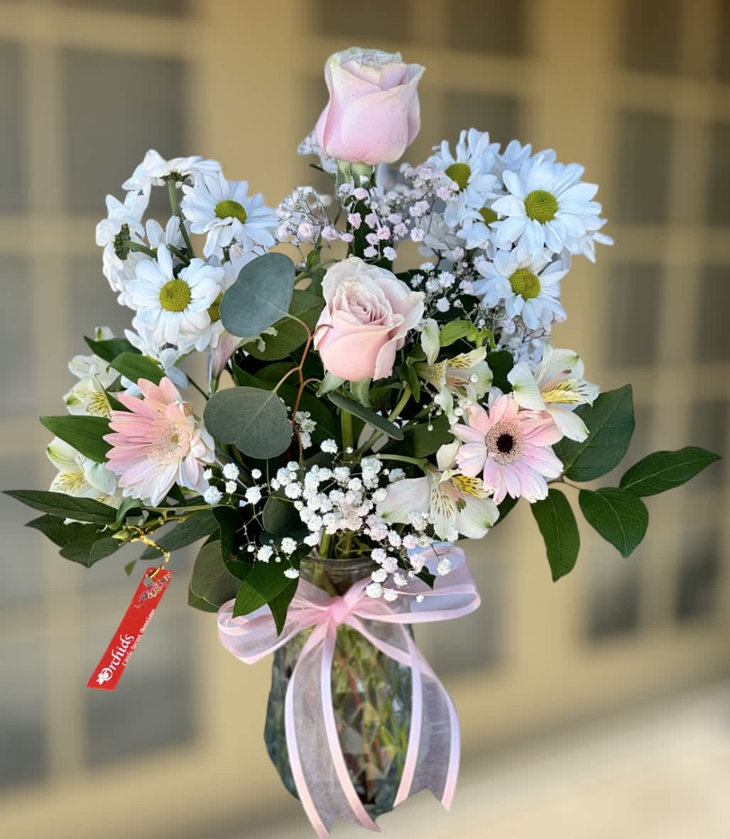 Brilliant White &amp; Pink Rose Gerbera Daisy Bouquet - Delight your recipient with Orchids Little Secret Boutique Brilliant pink roses surrounded by white blooms, pink gerbera daisies, and lush greens, beautifully arranged in a "7 clear glass vase. A beautiful and soft bouquet that loved ones will adore for any occasion or Mother's day gift!