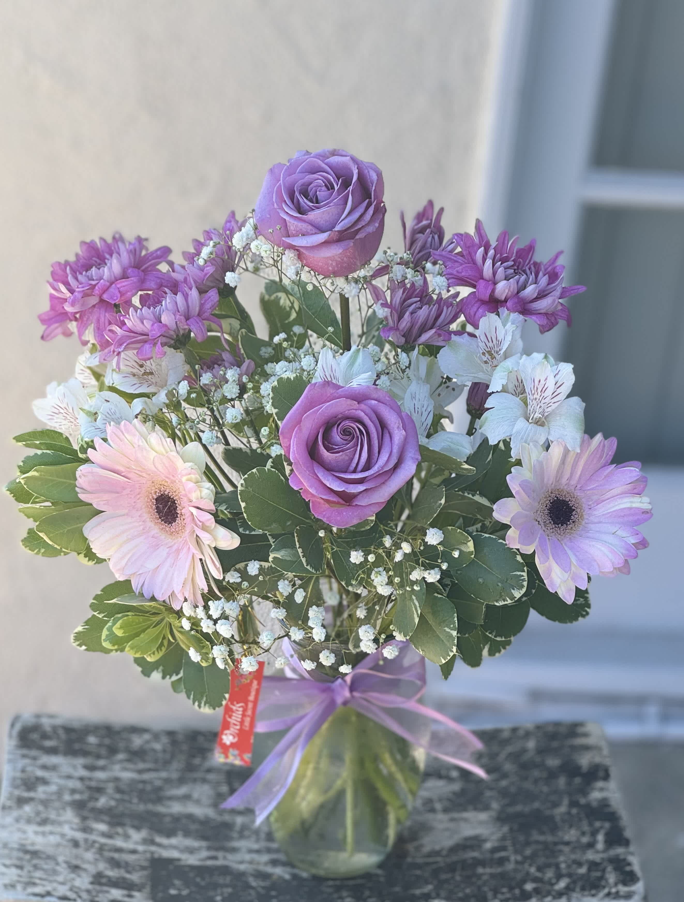 Brilliant Lavender Roses &amp; White Bouquet  - Brighten the home or office with beauty of lavender roses, gerbera daisies, and white blooms in a "7 glass vase. A wonderful gift to help celebrate an anniversary, a birthday, or just because. 