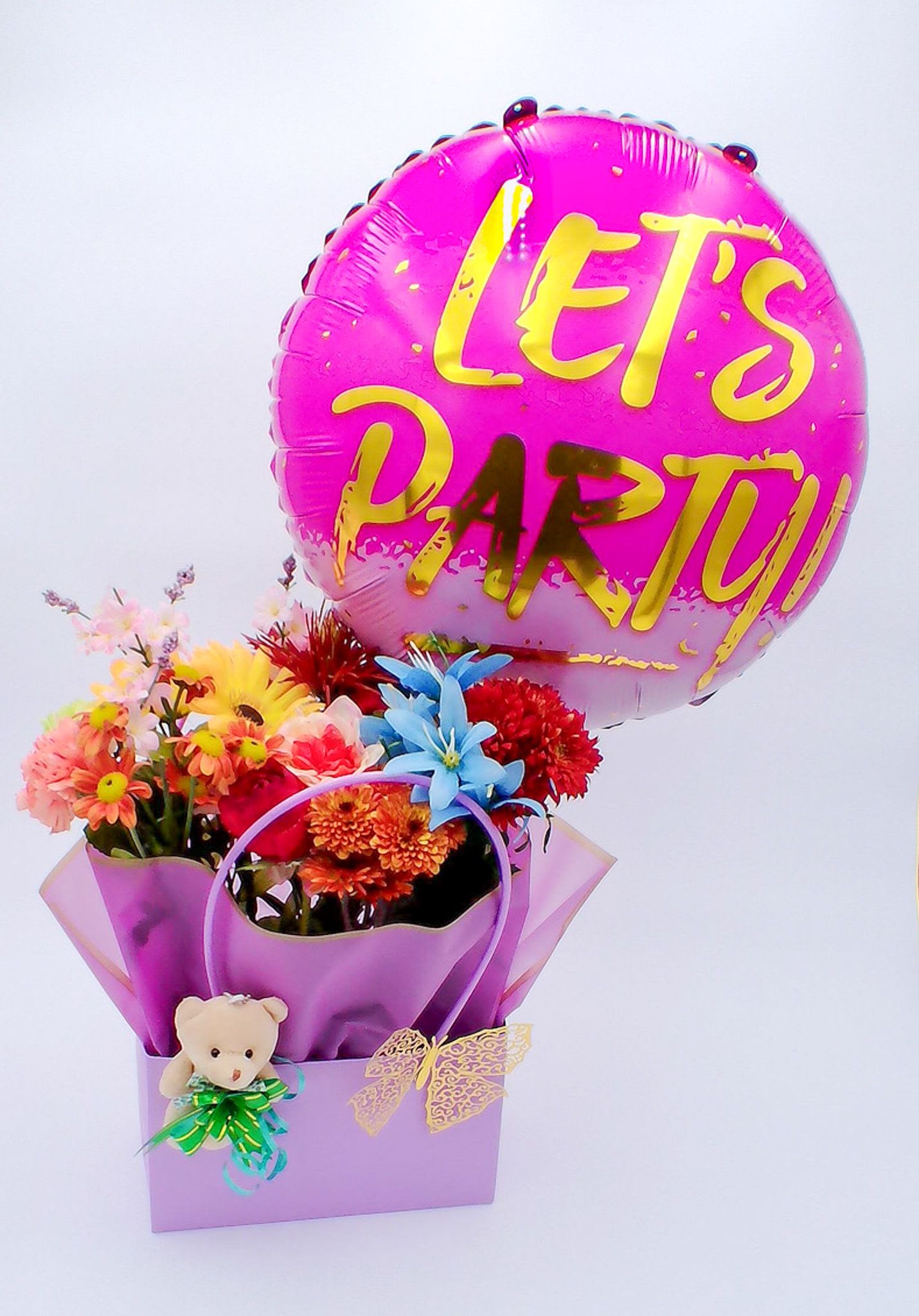 Let's Party Flower Gift Bag with Balloon/Teddy Bear - Mixed Fresh Flowers (14–16 stems): a colorful blend of 8 carnations, 2 chrysanthemums, 2 daisies, and 2 roses. 18-inch Foil Balloon (1 pc) Mini Teddy Bear (11 cm / 6 cm)  Decorative plastic ribbon (1) Decorative Golden Butterfly (1 pc) Reusable Gift Bag (32.5cm*22cm*13cm) Total Weight:700 g
