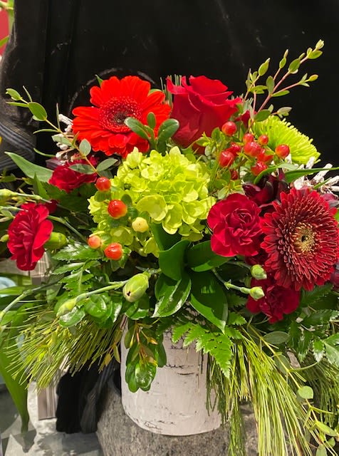 Frosty Fun Arrangement - Here is a fresh new design in white birch that is cheerful, pretty and priced just right for the holidays.  Nestled among a varied mix of cedar, pine and balsam greenery are the deep, rich colors of the season; Gerberas, hypericum berries, eucalyptus and mini dianthus.  Just right for so many people and occasions.   