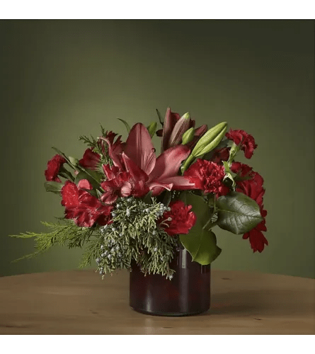 The Cranberry Bouquet - The Cranberry Bouquet Add a touch of sophistication with the jewel tones of The Cranberry Bouquet. This dynamic arrangement brings new life to classic stems while gerbera daisies and carnations showcase a rich red palette fit for the holiday.   Please Note: The bouquet pictured reflects our original design for this product. While we always try to follow the color palette, we may replace stems to deliver the freshest bouquet possible, and we may sometimes need to use a different vase.
