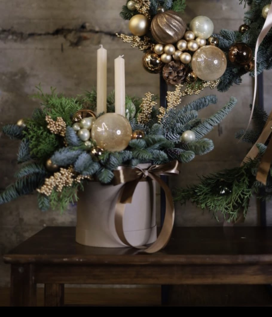 Holiday White Ceramic Cylinder- Centerpiece  - Standard: 5” white ceramic cylinder   Deluxe: 6.5” white ceramic cylinder   Seasonal greens, white and gold accents and 2 white taper candles. Lasts about 6 weeks  An elegant choice!!!!