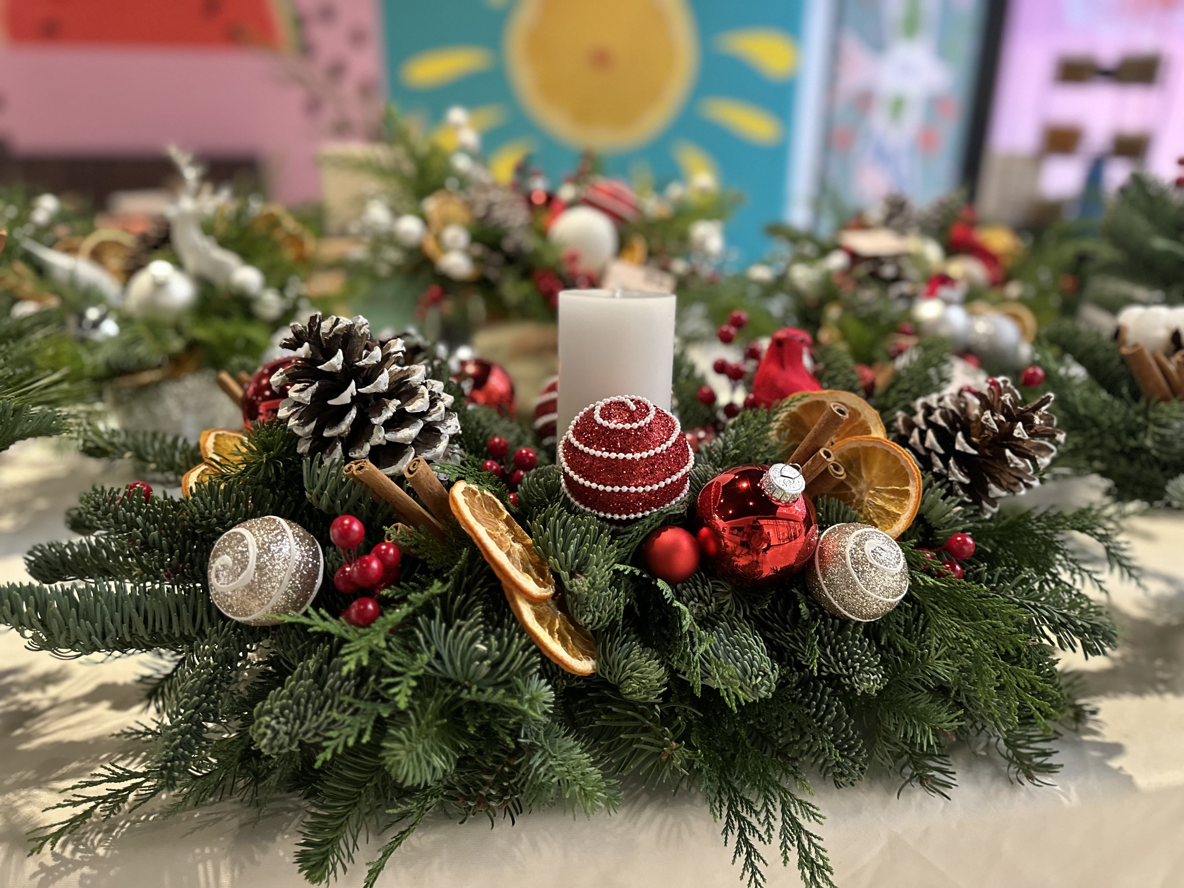 Holiday- Long Centerpiece: red &amp; white - Seasonal foliage, Dried orangs, cinnamon, pine cones, res &amp; White ornaments/ accents &amp; 6” white pillar candle.   About 25” long  Lasts about 6 weeks