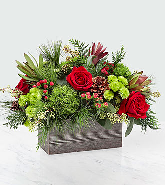 Christmas Cabin Bouquet  - This stunning bouquet is handcrafted to bring the cozy feel of the holidays into your home. An array of red roses, green button pompons, and seeded eucalyptus is set in a weathered, wooden rectangular box and can make any morning feel like a cozy Christmas morning. 