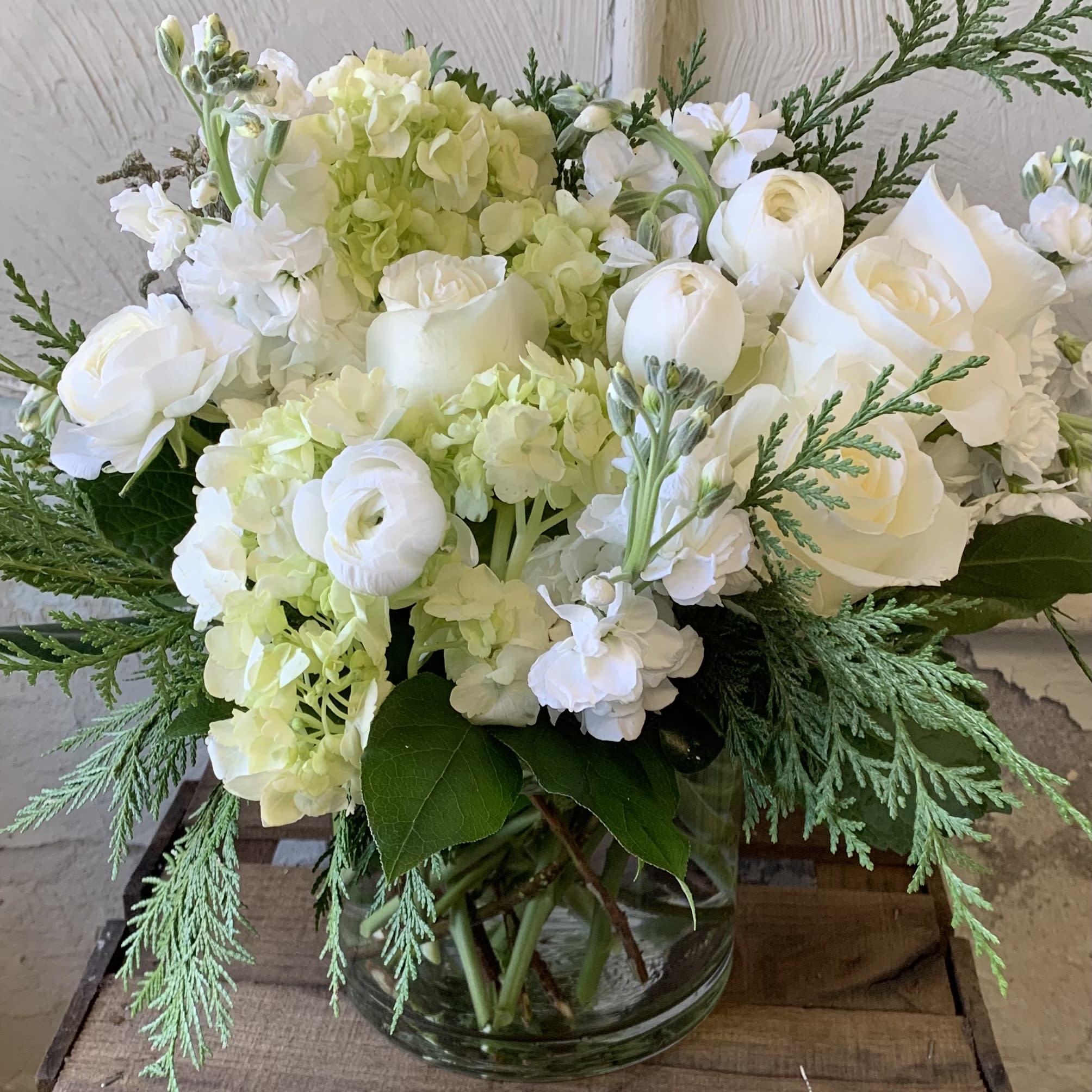 Arctic Cheer - White roses, tulips, stock, and ranunculus. Find all the beauty of winter, minus the cold, when you order these flowers! 