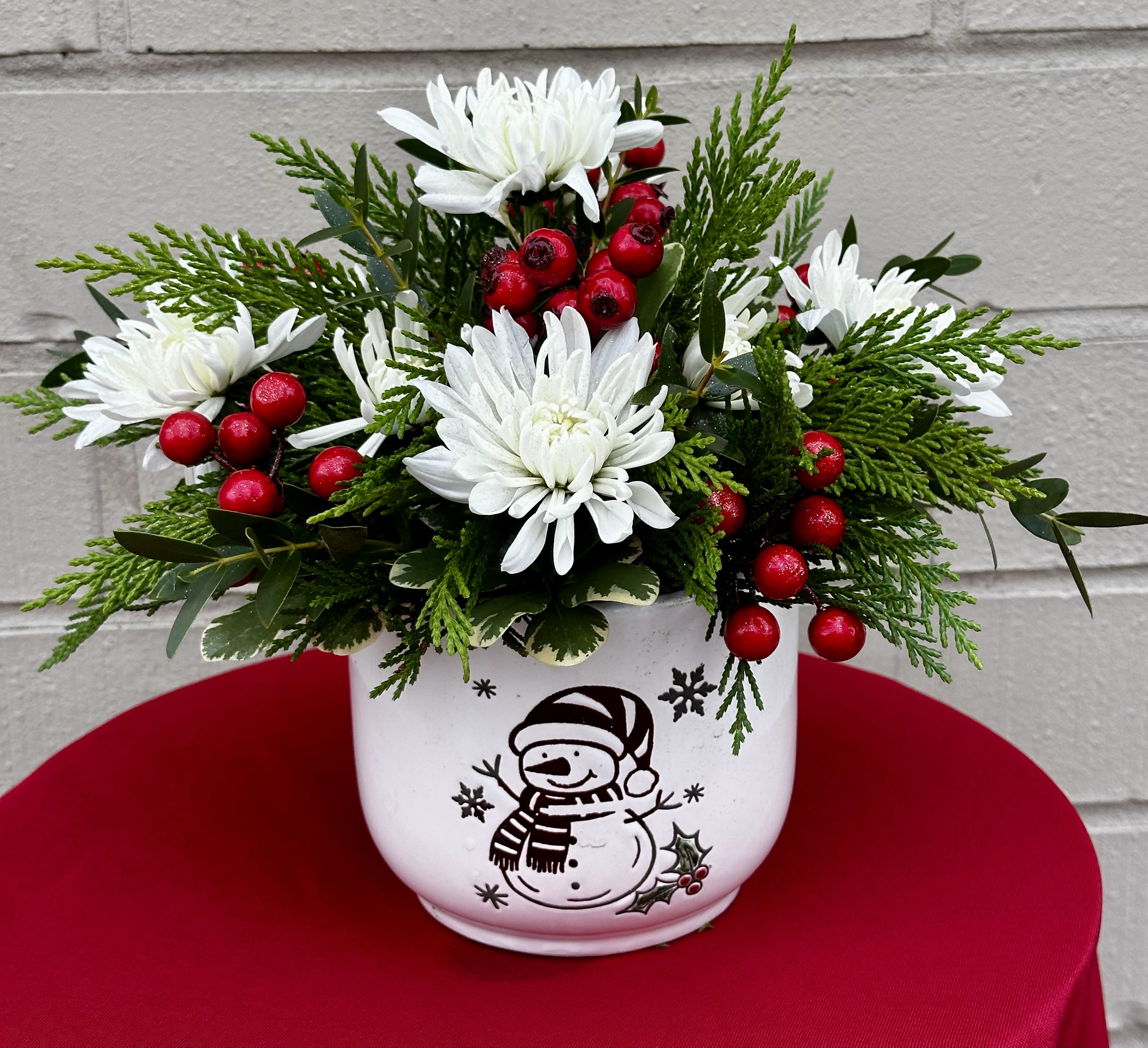 Mr. Frosty  - White Flowers, Red Berries, and Mixed Winter Greens  Arrive in a Mr. Frosty Ceramic Container.  