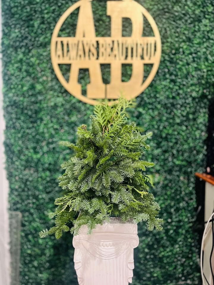 Simple Holiday Tree - Our Handmade Christmas Tree Arrangement is a festive, eye-catching centerpiece designed to bring the holiday spirit into any home. Crafted with care and attention to detail, this arrangement features a lush base of vibrant green pine branches that mimic the fullness of a real Christmas tree.   Deluxe and Premium are taller trees. Picture is not exact sizing*