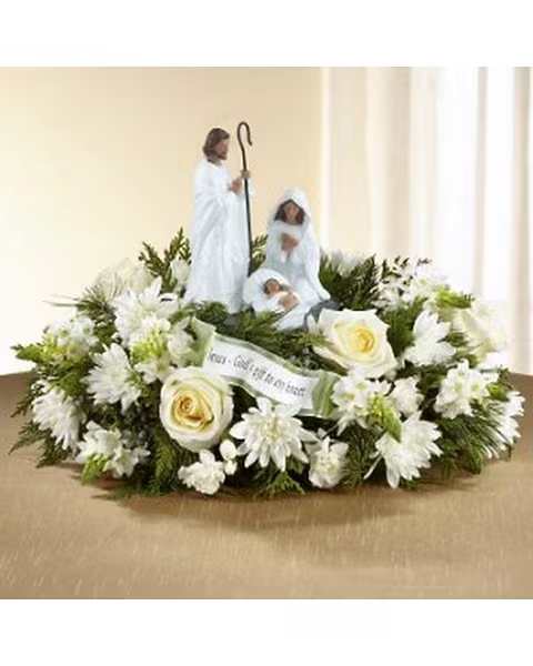 God's Gift Nativity - Celebrating the reason for the season with meaning, blooming elegance, and perfect beauty, this gorgeous holiday centerpiece is an exceptional way to bring light and Christmas joy to your holiday gathering.White roses, alstromeria, chrysanthemums, and mini carnations draw the eye in, surrounded by an assortment of fresh Christmas greens. Arranged elegantly around a keepsake nativity figurine featuring Mary, Joseph, and Baby Jesus, with an accent piece among the flowers that reads &quot;God's Gift of Love.&quot; This centerpiece is a wonderful way to share in the good news with friends and family near and dear to your heart.