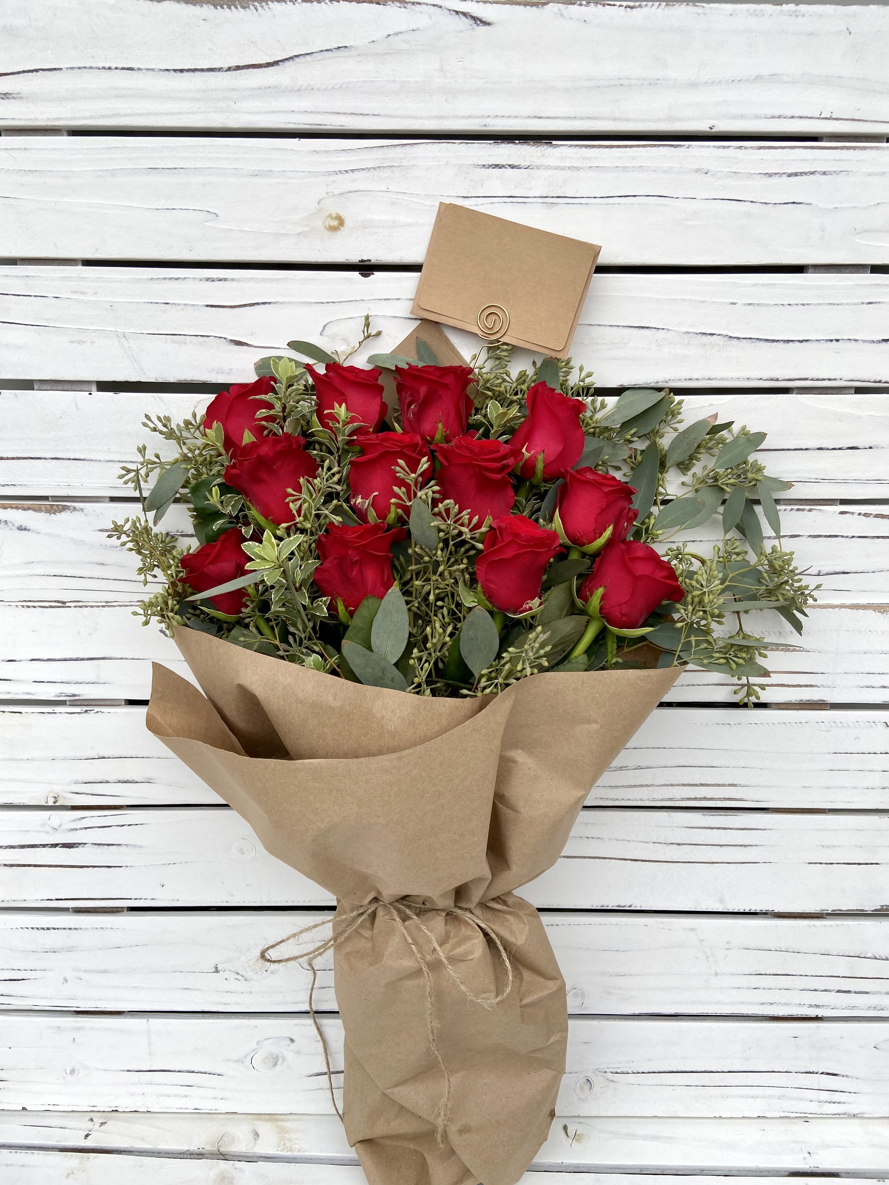 1 Dozen Red Rose Bouquet - Shade of red color and greens may vary. Brown Paper Bouquet comes with a moisture pak and is wrapped in brown paper and tied with twine.  