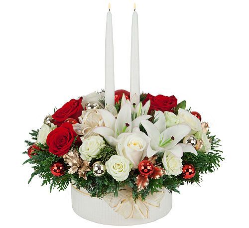 Abundant Joy - A ribbon adorned while bowl is abundantly arranged with red roses, white roses, white lilies, holiday ornaments, golden holly and two elegant white taper candles. Surely this expert, hand made gift will bring joy and beauty to any home.