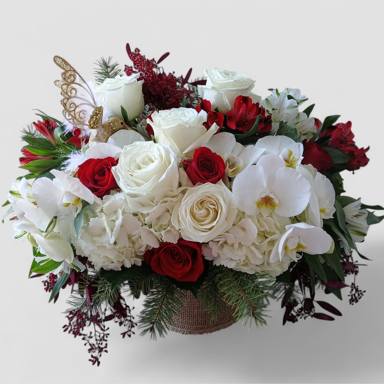 Winter Grace Luxe Centerpiece - A graceful mix of white orchids, red and white roses, hydrangeas, evergreens, and eucalyptus - styled in a modern vase wrapped in soft vanilla jute ribbon. Designed to bring quiet winter beauty and timeless elegance to any table. Available for delivery throughout Haddon Township, Haddonfield, Cherry Hill, and nearby South Jersey towns.