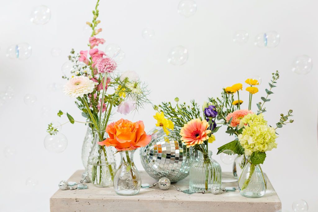 Bud vase collection - Why send just one when you can send 6?  This bud vase collection is fun for the recipient to place around the house or stagger down a dining room table.  We use the best seasonal blooms and flowers may vary however overall look won't change.  Disco ball not included.