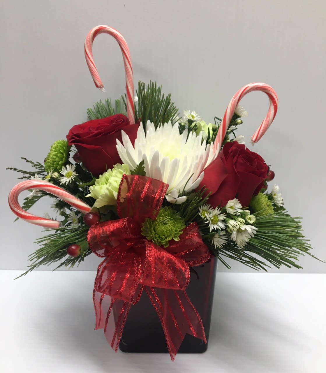 Candy Cane Kisses - Beautiful Candy Cane arrangement in a square vase with Roses, Carnations, Hypericum, Monte  and Christmas greens