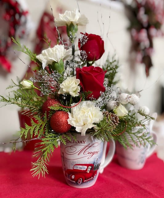 Cocoa Christmas Greetings - Give the gift of seasonal evergreens and flowers with a keepsake mug perfect for holiday hot chocolate (included!). Bouquet will come in one of the mugs pictured while supplies last-- if you have a preference, let us know in the special instructions.