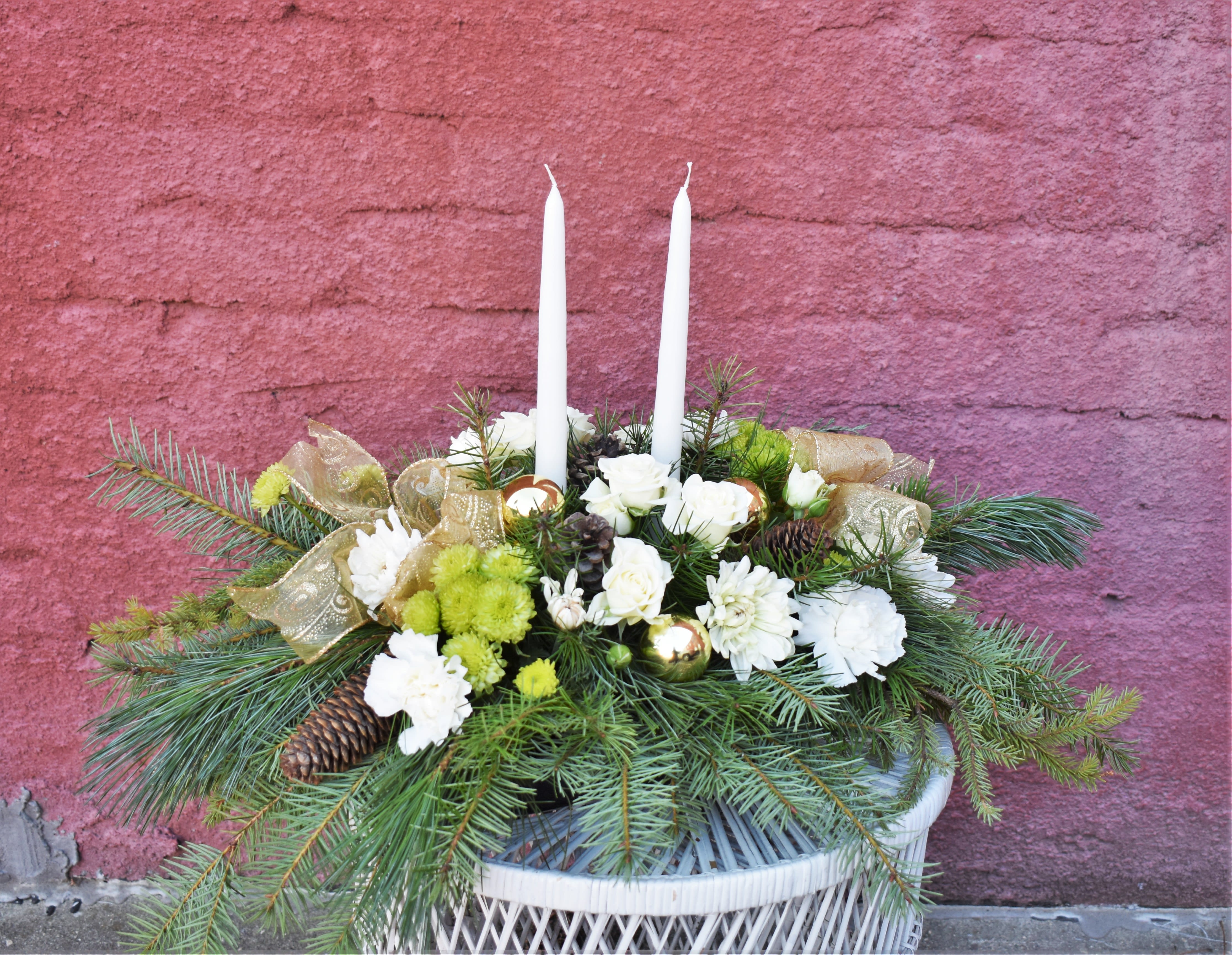 Oh Holy Night - Soft and angelic, this wintery bouquet is brimming with fresh pine, white spray roses, mums, carnations, green button mums, and pinecones. White double candles, gold bows, and ornaments accent the bouquet and make for a heavenly way to celebrate the season! 