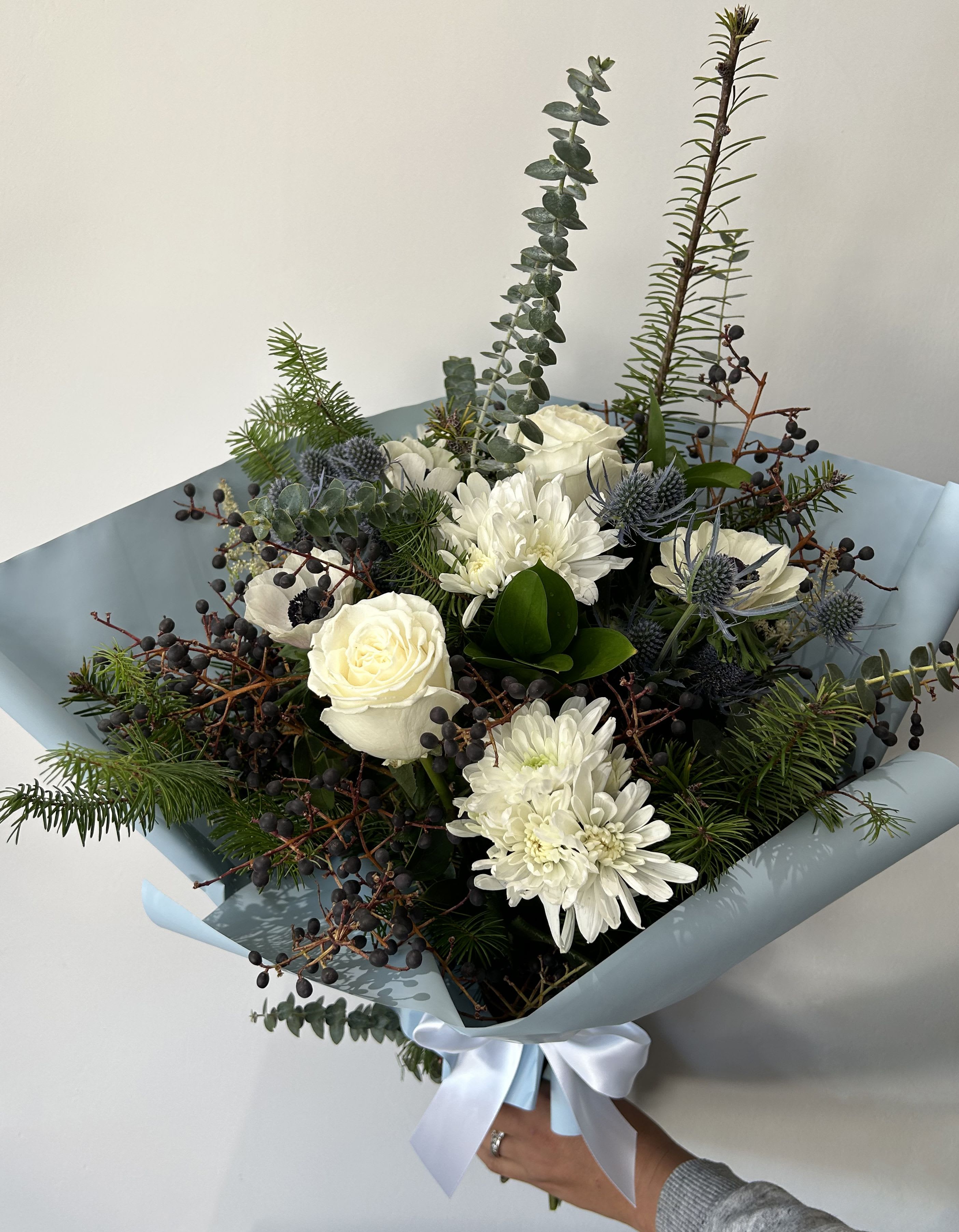 Holiday Blue's - Seasonal blue and white flowers arranged with holiday greens into a hand-tied bouquet. 