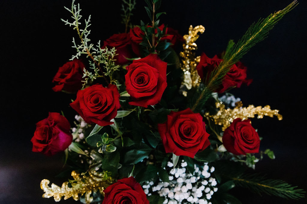 Christmas Roses - 12 classic velvety red roses designed with winter pines, baby breath and a touch of sparkly gold.