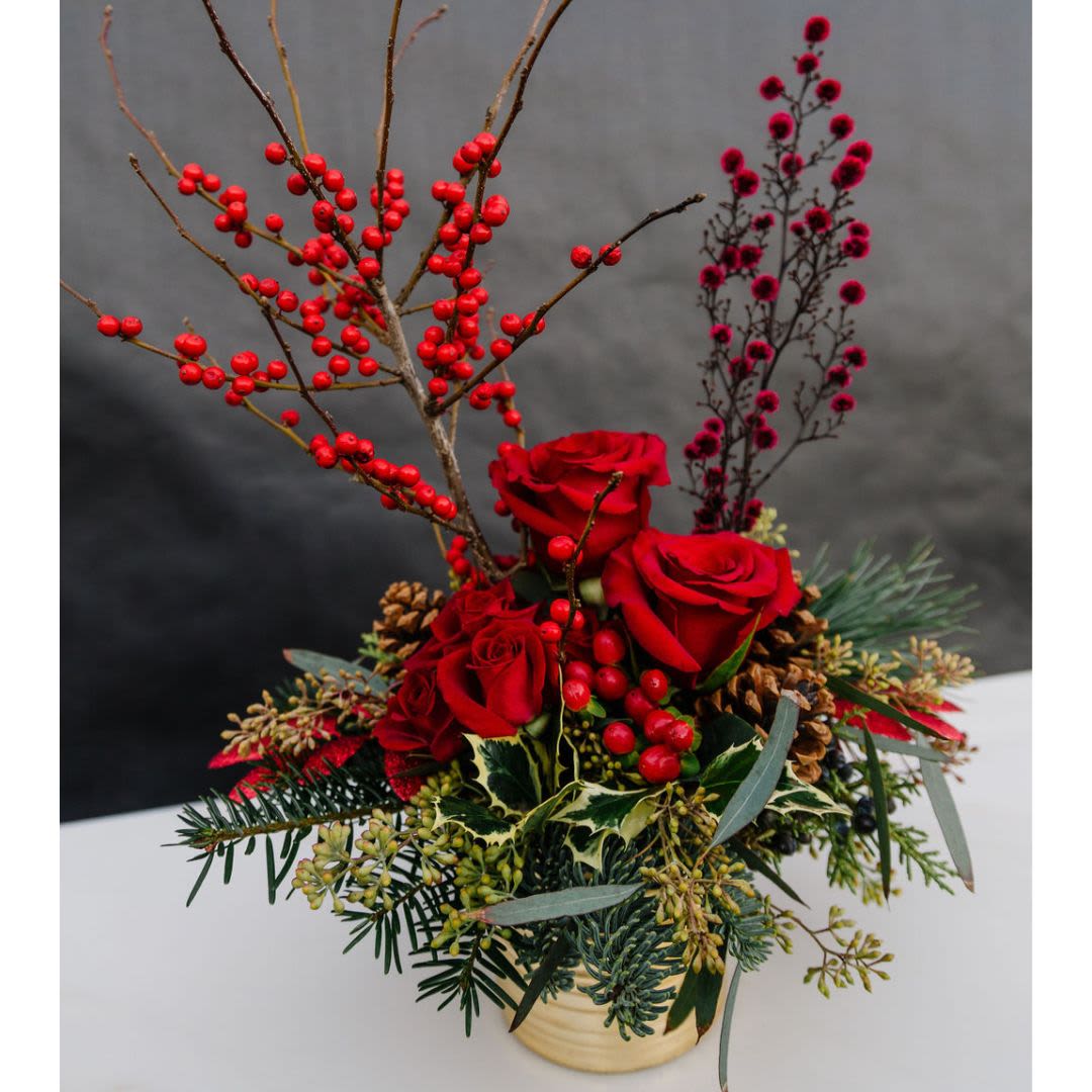 Crimson Woodland - This stunning holiday arrangement features a rich blend of seasonal blooms and greenery, designed to evoke a sense of warmth and festive cheer. The combination of rich hues, soft textures, and festive elements makes &quot;Winter's Embrace&quot; a perfect holiday piece, radiating both elegance and warmth.