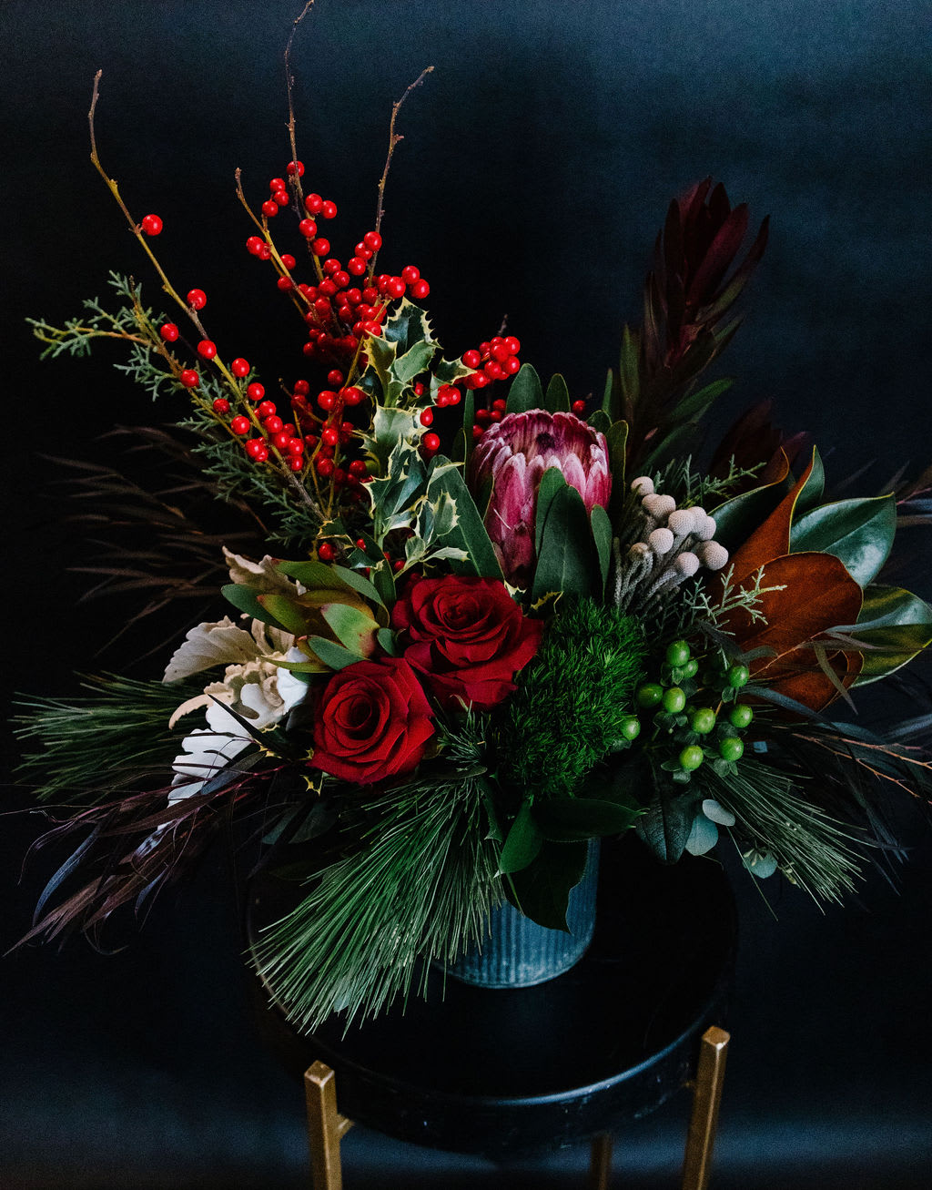 Rustic Holiday - A festive holiday arrangement in a rustic tin container with pine cones winter pine and magnolia accents.