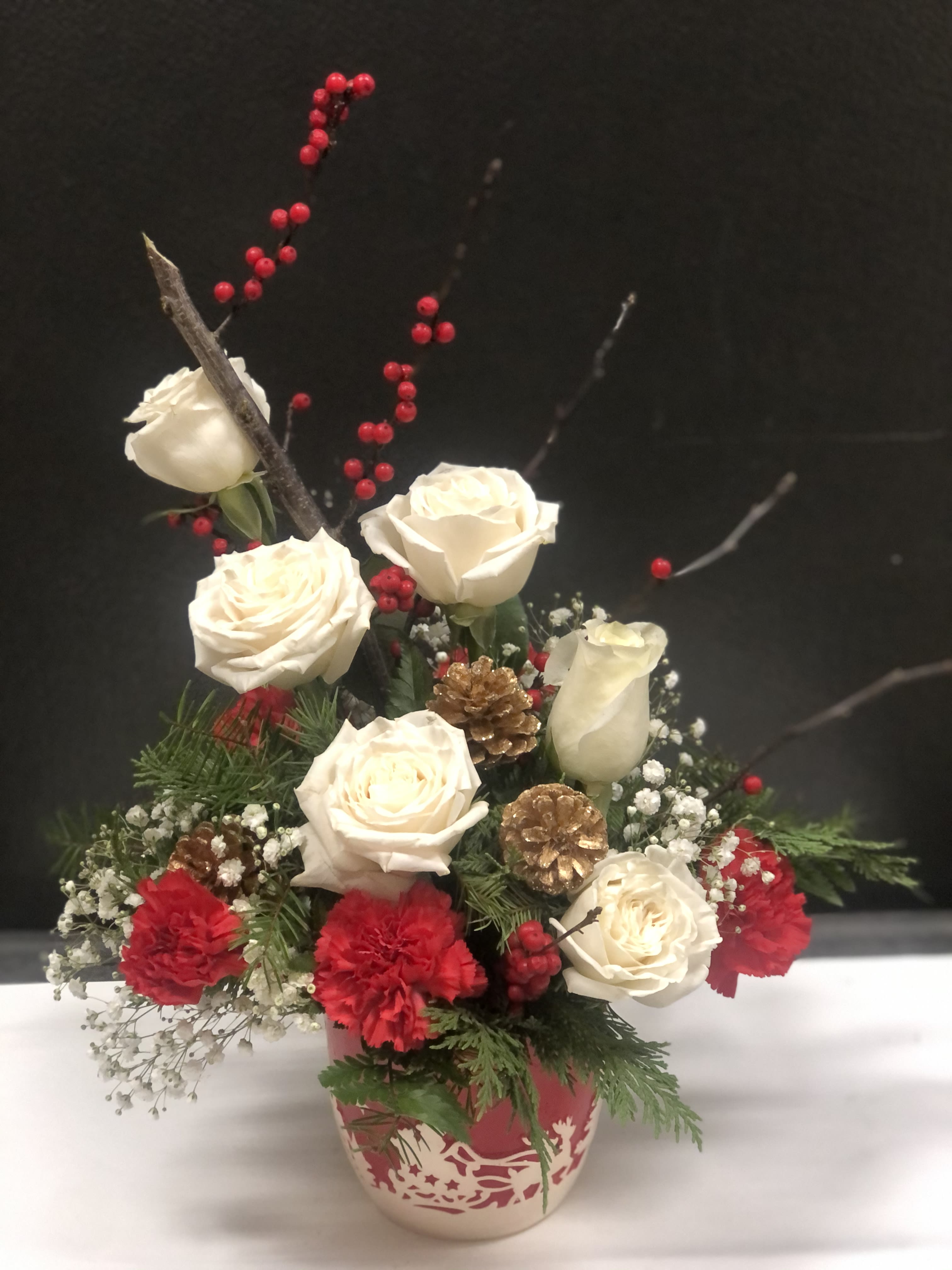 Holiday spirit - This beautiful  red and white arrangement , it is made with white roses , red carnation, Christmas berries, pine cone , baby's breath and the Christmas greenery . it is a perfect gift for Christmas and the winter holiday.  