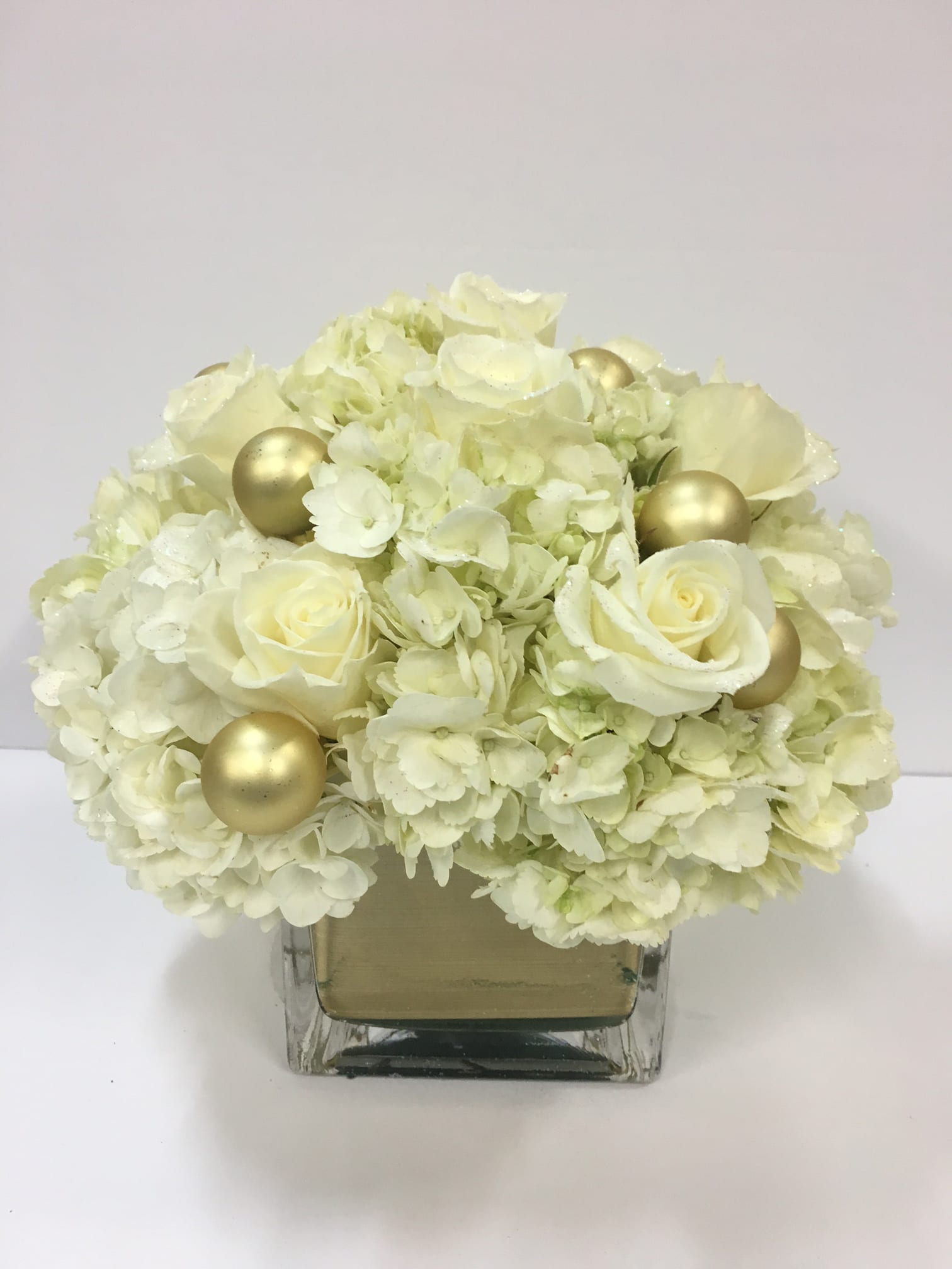Frost - Send this frosty winter arrangement  of white hydrangea and roses sprinkled with diamond dust. Arranged in a glass cube.