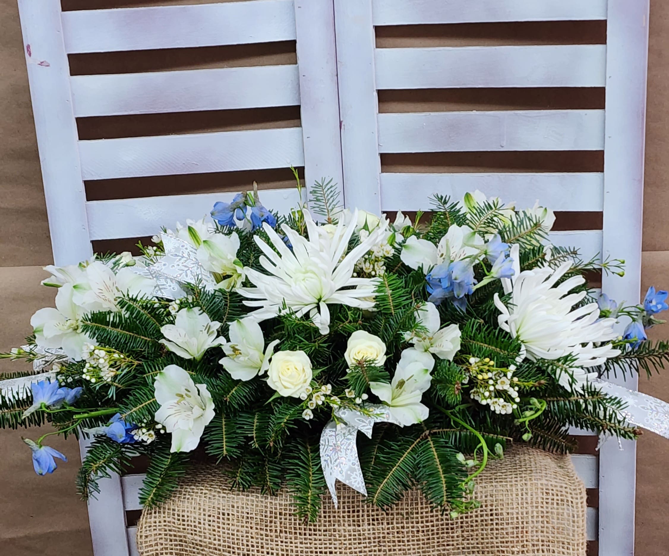 Dedication  - A beautiful centerpiece dedicated to the celebration on Hanukkah with white spider mums, delphinium, alstroemeria, spray roses and wax flower trimmed with a touch of sparkle. 