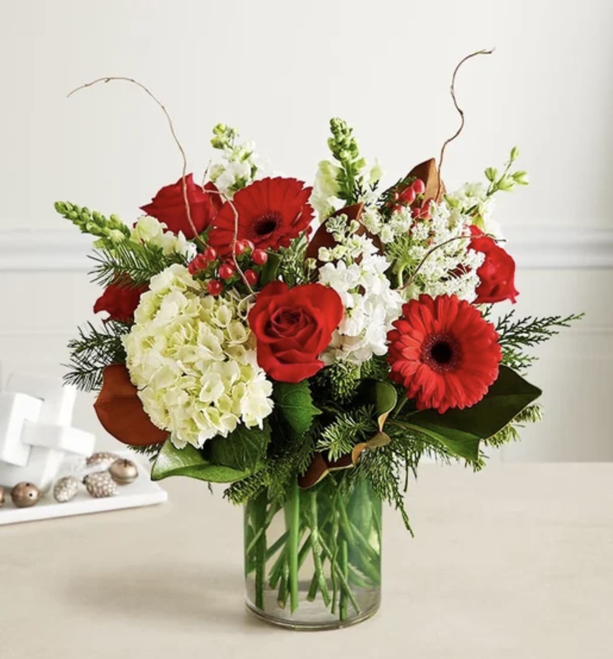 Abundant Christmas Blessings - Some gifts have a way of capturing the many blessings of the Christmas season. Our luxury gathering brings together a unique variety of white hydrangeas with roses and Gerbera daisies for a festive splash of holiday red. Curly willow and lush greens add a rustic, nature-inspired feel. With exquisite style and texture, it’s a beautiful reminder of all we have to celebrate.