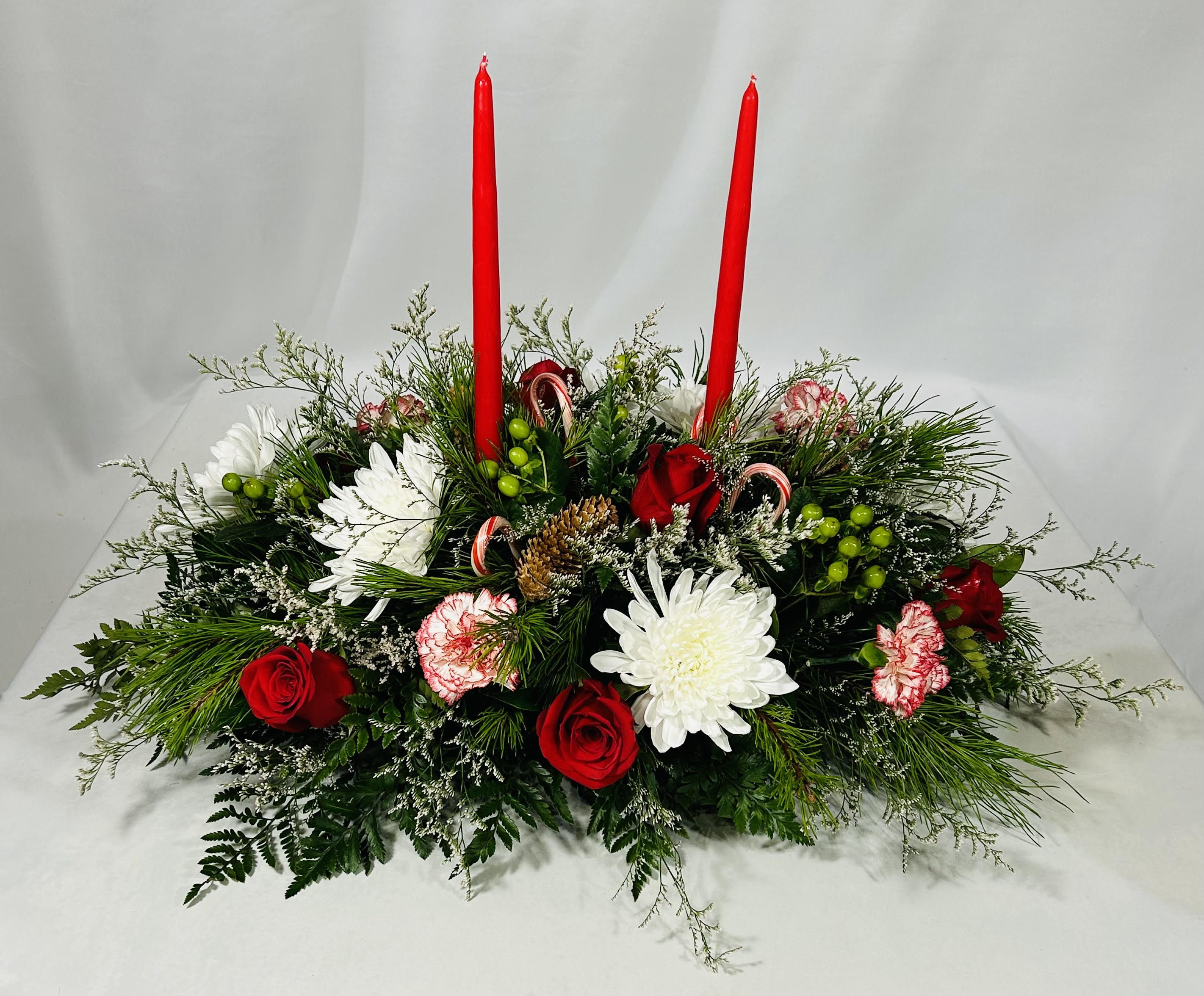 Candy Cane Christmas Centerpiece - Beautiful Candy Cane Christmas Centerpiece is sure to be a hit this season when you order this joyful Christmas arrangement for your table. This lovely centerpiece will light up the holiday festivities beautifully for your own table or to send to someone.   17" h x 24" w