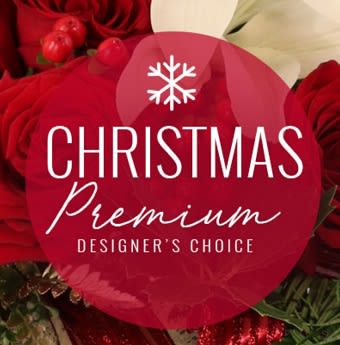 Premium Christmas Designers Choice - A mix of premium holiday flowers and greens. Colors will include red, white and green. Arrangement will be beautifully arranged with flowers to include roses, berries, lilies and more. Designed in a vase or large basket.